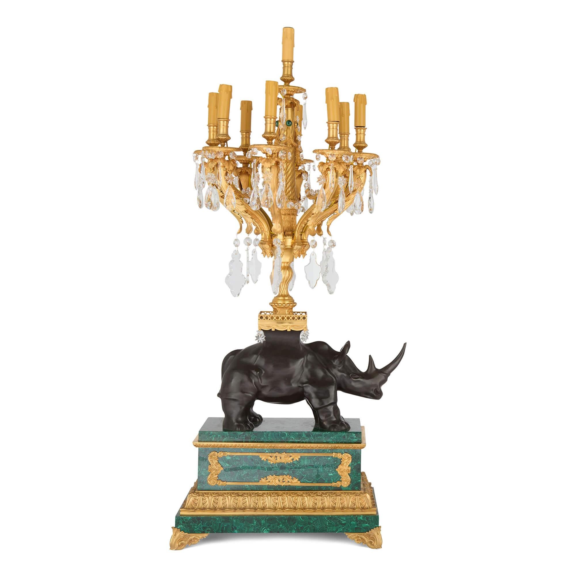 Gran pareja de candelabros de mesa de ormolina y malaquita rinoceronte
Francés, siglo XX
Altura 134 cm, anchura 55 cm, profundidad 49 cm

Este notable par de candelabros se centra alrededor de rinocerontes de bronce patinado finamente fundidos, cada