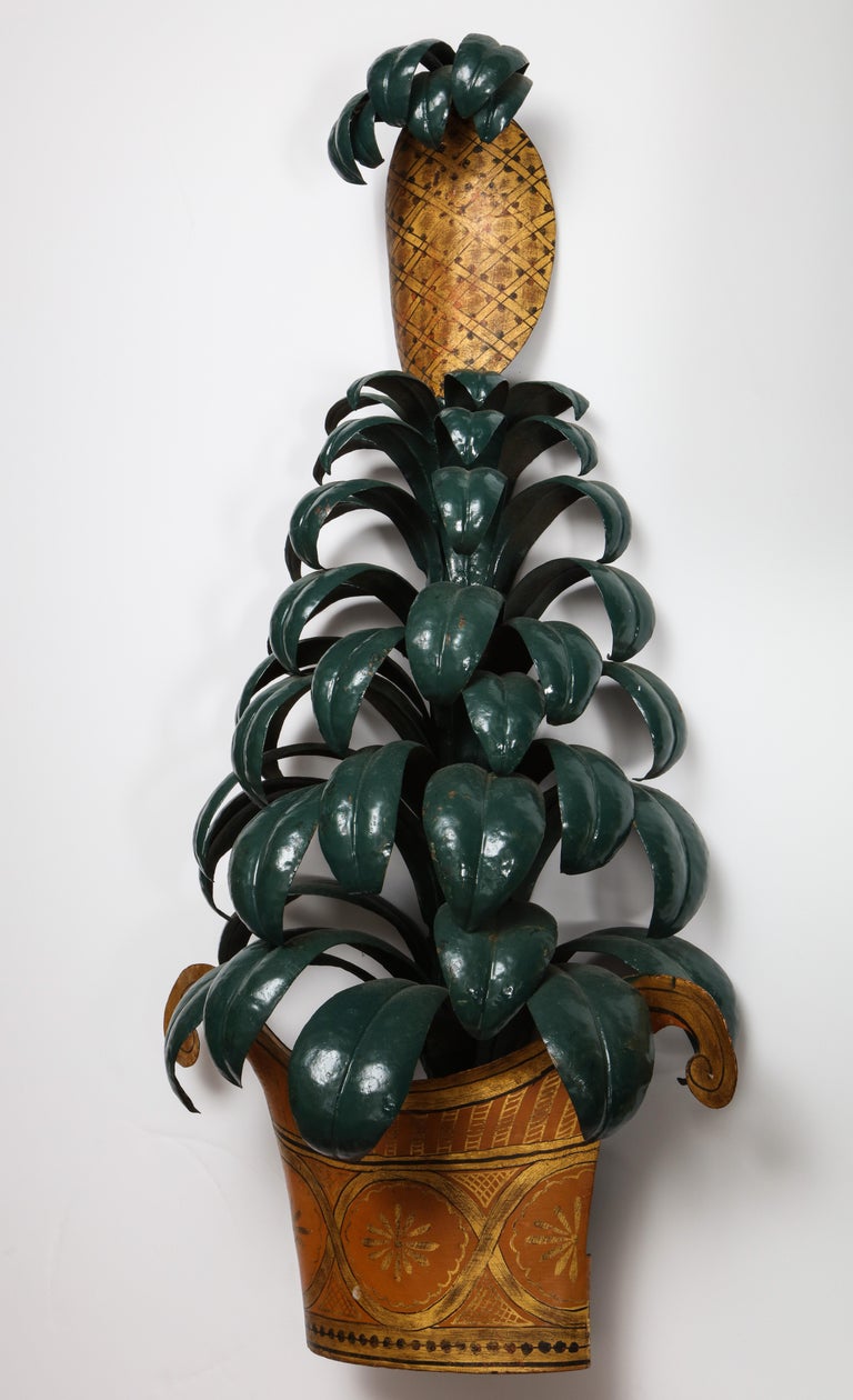 The tole sconces of unusual size made of painted tole, each topped with a pineapple element over tiers of leaves issuing from an empire form basket.
 