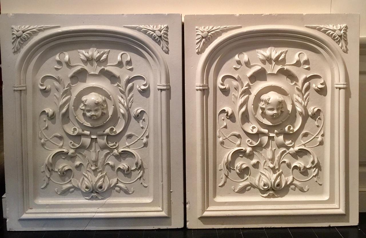 Pair of vintage, Bas Relief, architectural plaster panels beautifully decorated with an all-over motif of leaves, curlicues, scrolls, plumes, feathers and a tulip, surrounding a lovely angel. Highly decorative. Rare to find a pair of this size, age