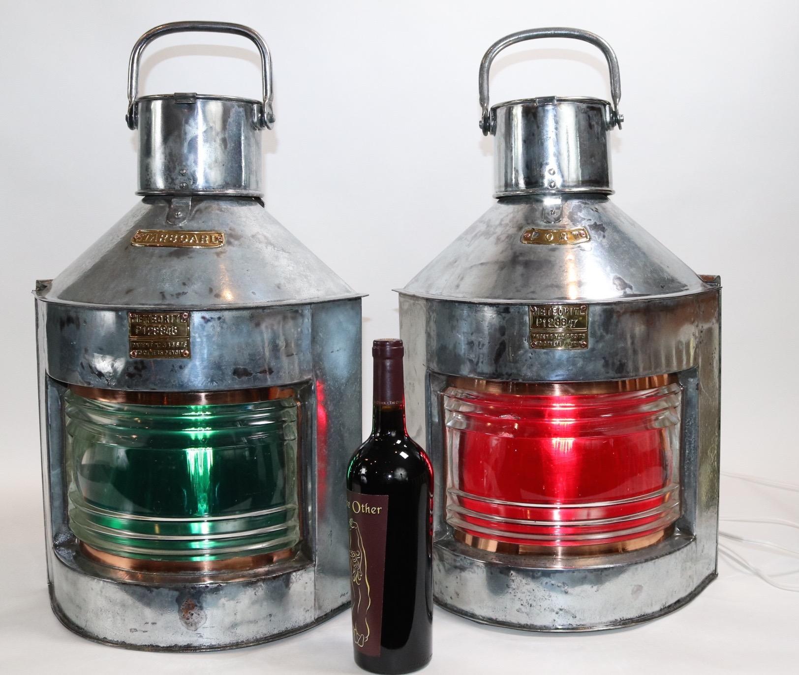 Substantial pair of port and starboard ships lanterns by the English firm Meteorite. With clear Fresnel lenses backed by red and green filters. The steel cases have been stripped and polished. With brass maker badges with sequential serial numbers.