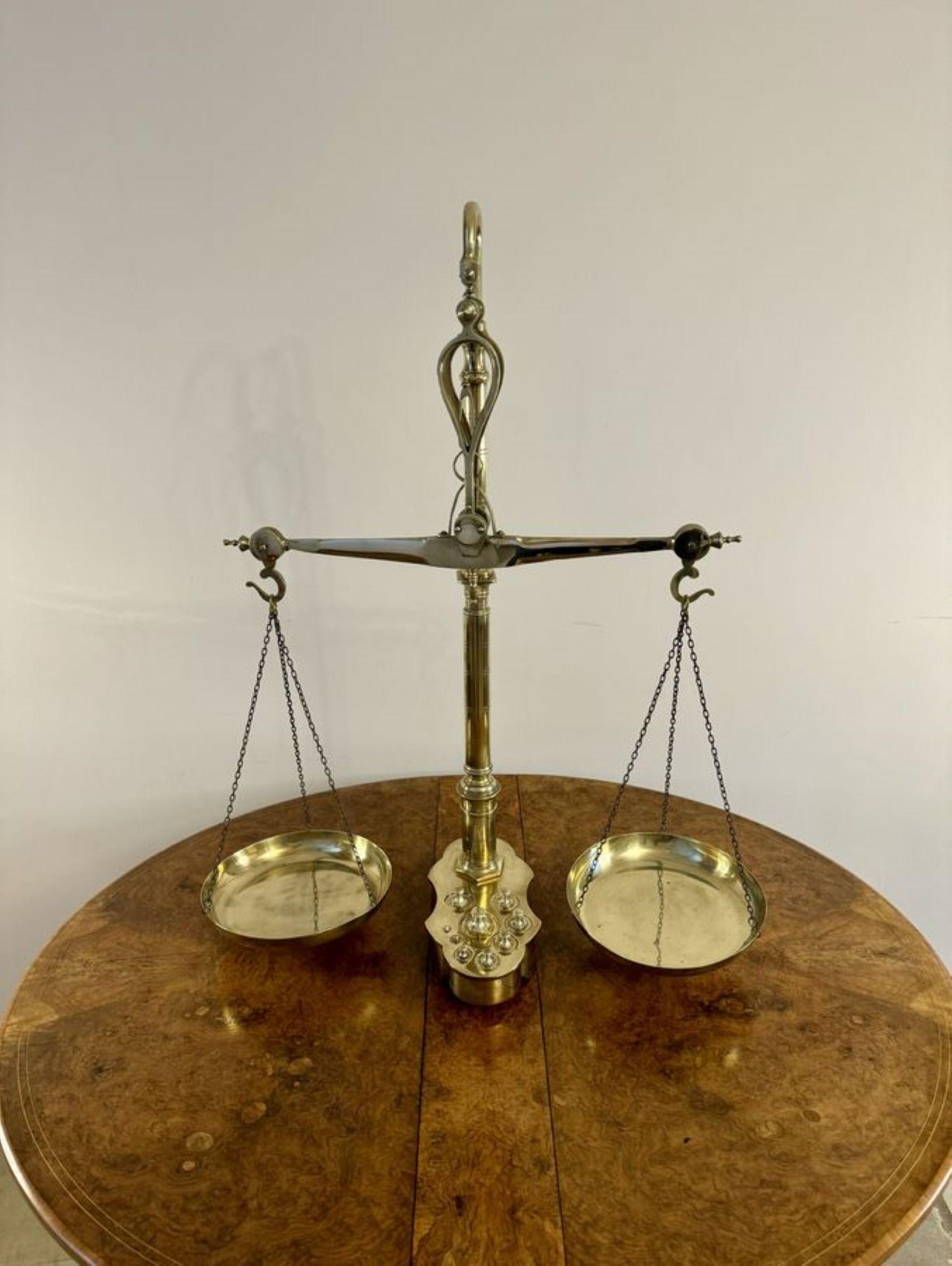 Large pair of quality antique Victorian brass beam scales and weights, having a large pair of Librasco brass beam scales, with a shaped beam with two circular brass pans hanging from tripod chains, with the original set of nine graduating weights