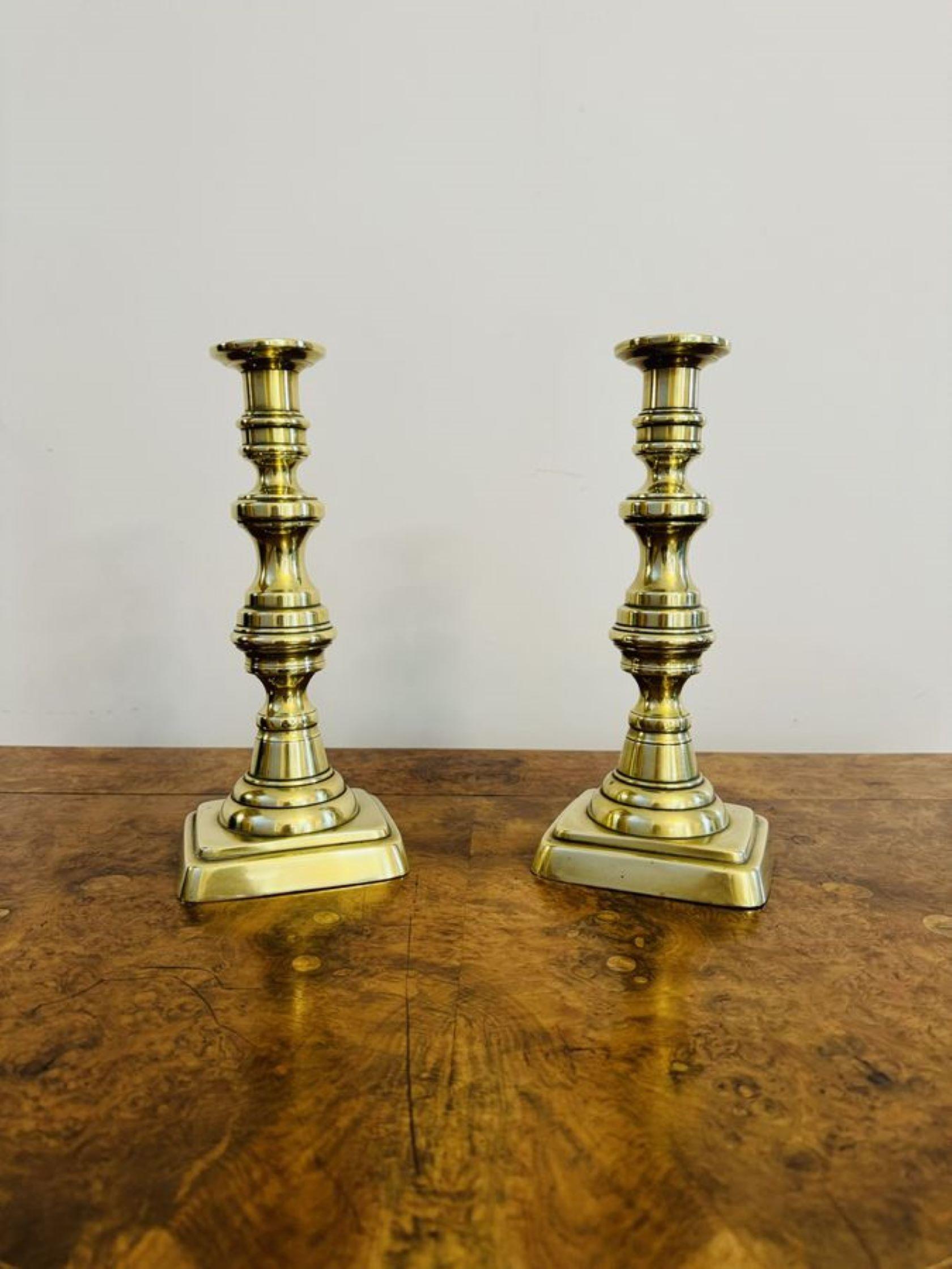 Large pair of quality antique Victorian brass candlesticks, having a large pair of Victorian brass candlesticks with turned shaped columns raised on rectangular shaped bases.

D. 1860