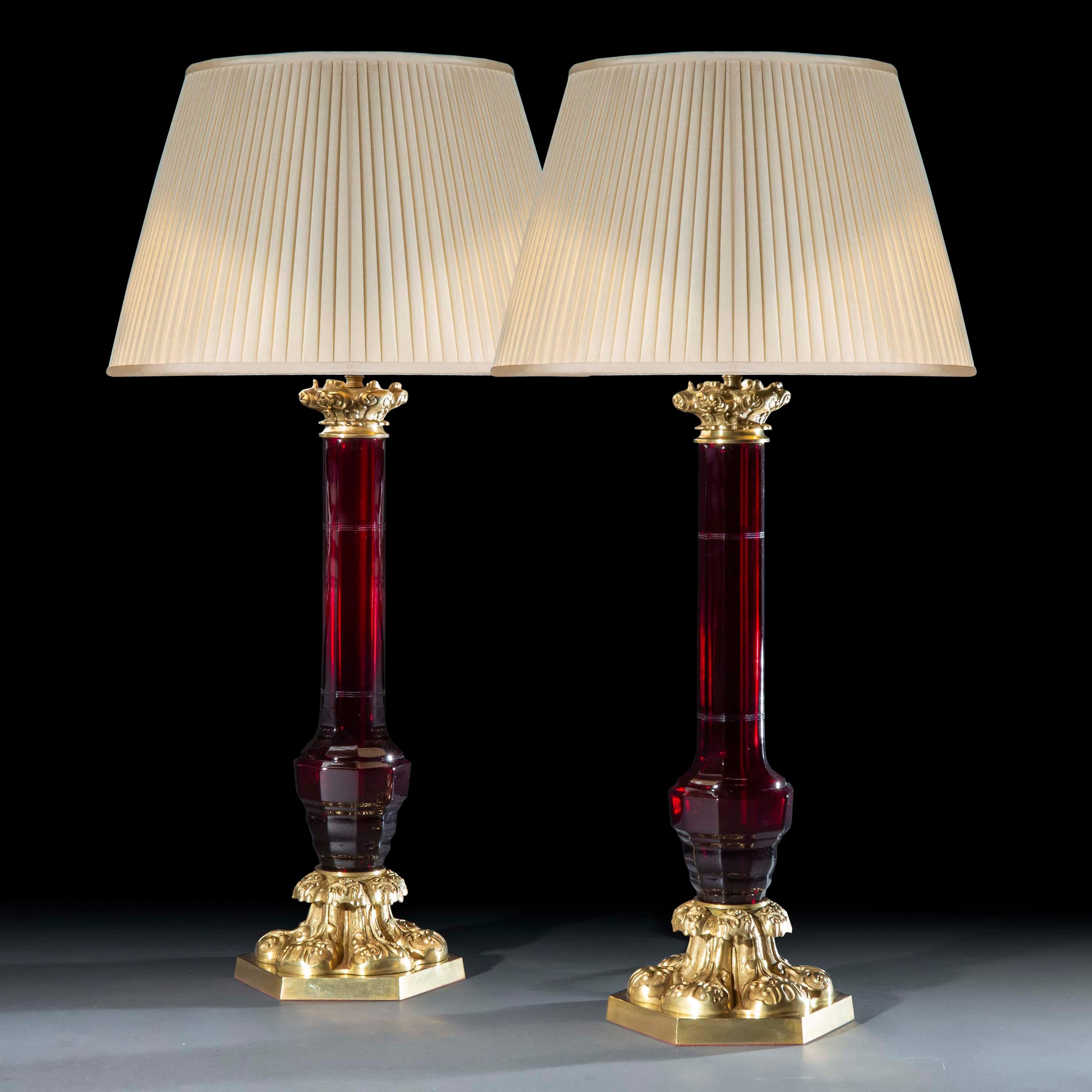 An opulent pair of ruby glass and brass table lamps of superb quality, fashioned as 19th century late Regency – early Victorian oil lamps.
England, mid-20th century.

Why we like them
We like their baroque exuberance and the superb, handmade