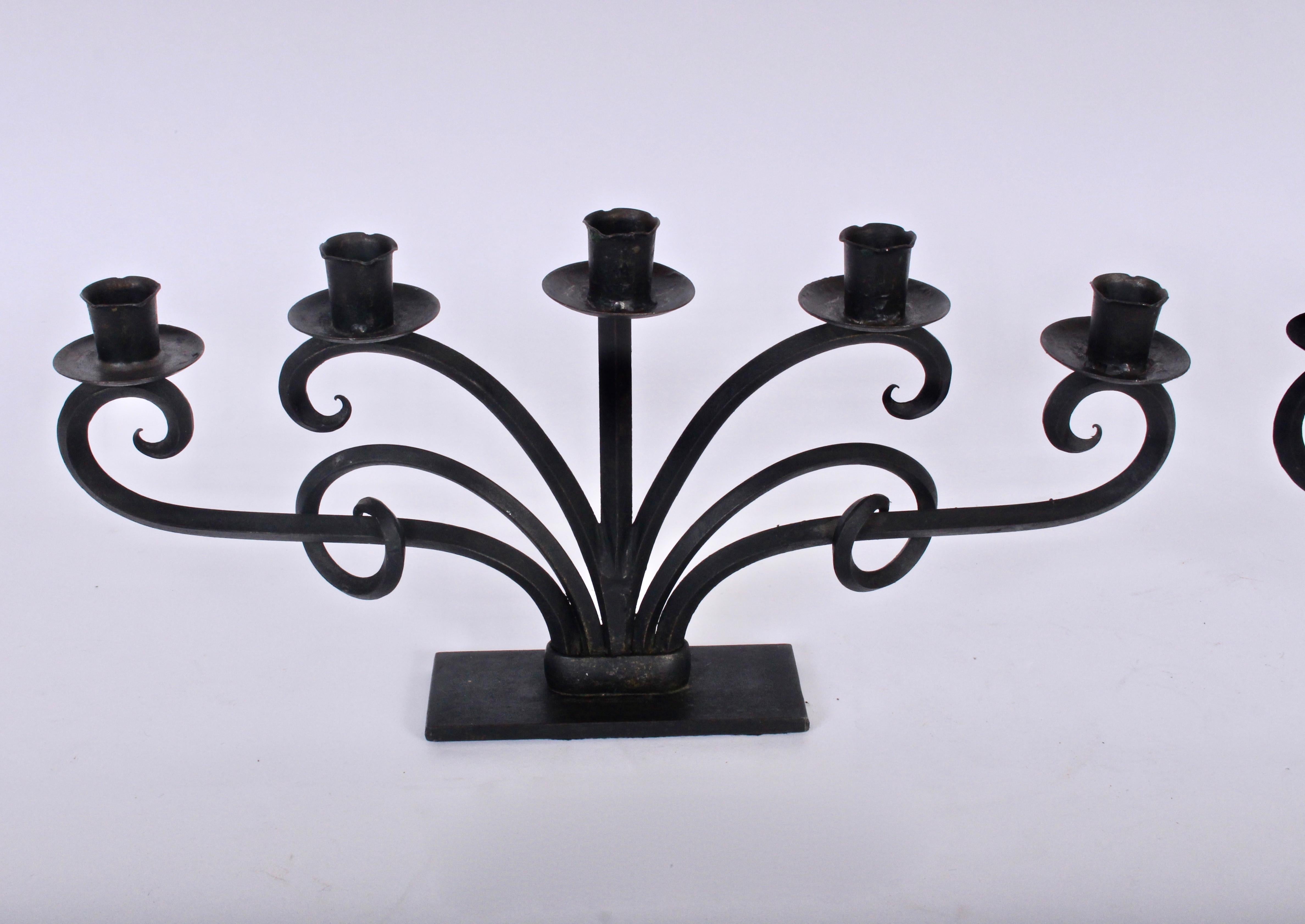 Wide Pair of Norwegian Modern handcrafted six branch scrolled black iron candlesticks, in the manner of Just Andersen.  With Iron bobeches for candle drippings and sculptural scroll design. Two pieces approximately three feet long when placed side