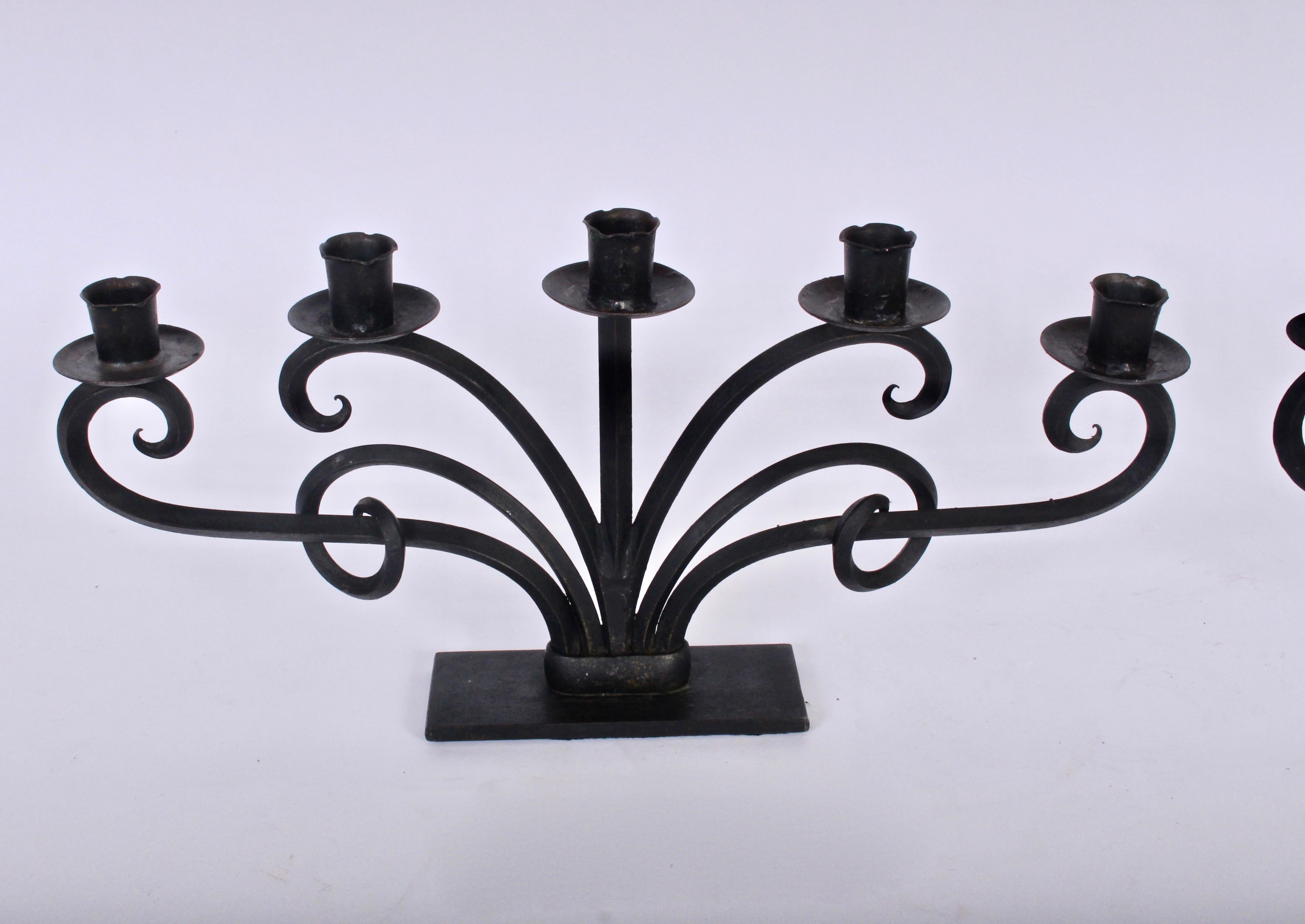 Ampia coppia di candelabri norvegesi moderni in ferro nero a sei rami, alla maniera di Just Andersen.  Con bobeches in ferro per le colature delle candele e design scultoreo a volute. Due pezzi lunghi circa un metro se affiancati. Eccellente per un