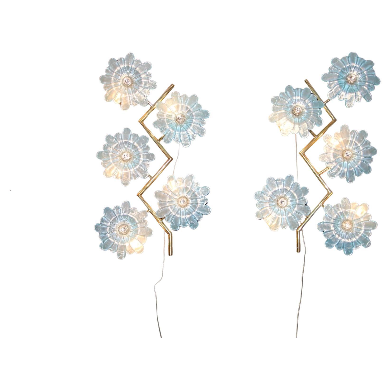 This beautiful pair of sconces features zig zag brass frame and 5 iridescent blue Murano glass flowers.These flowers were made by hand in Murano and their center piece is made of a crystal color glass studs.They are very romantic and unusual as well