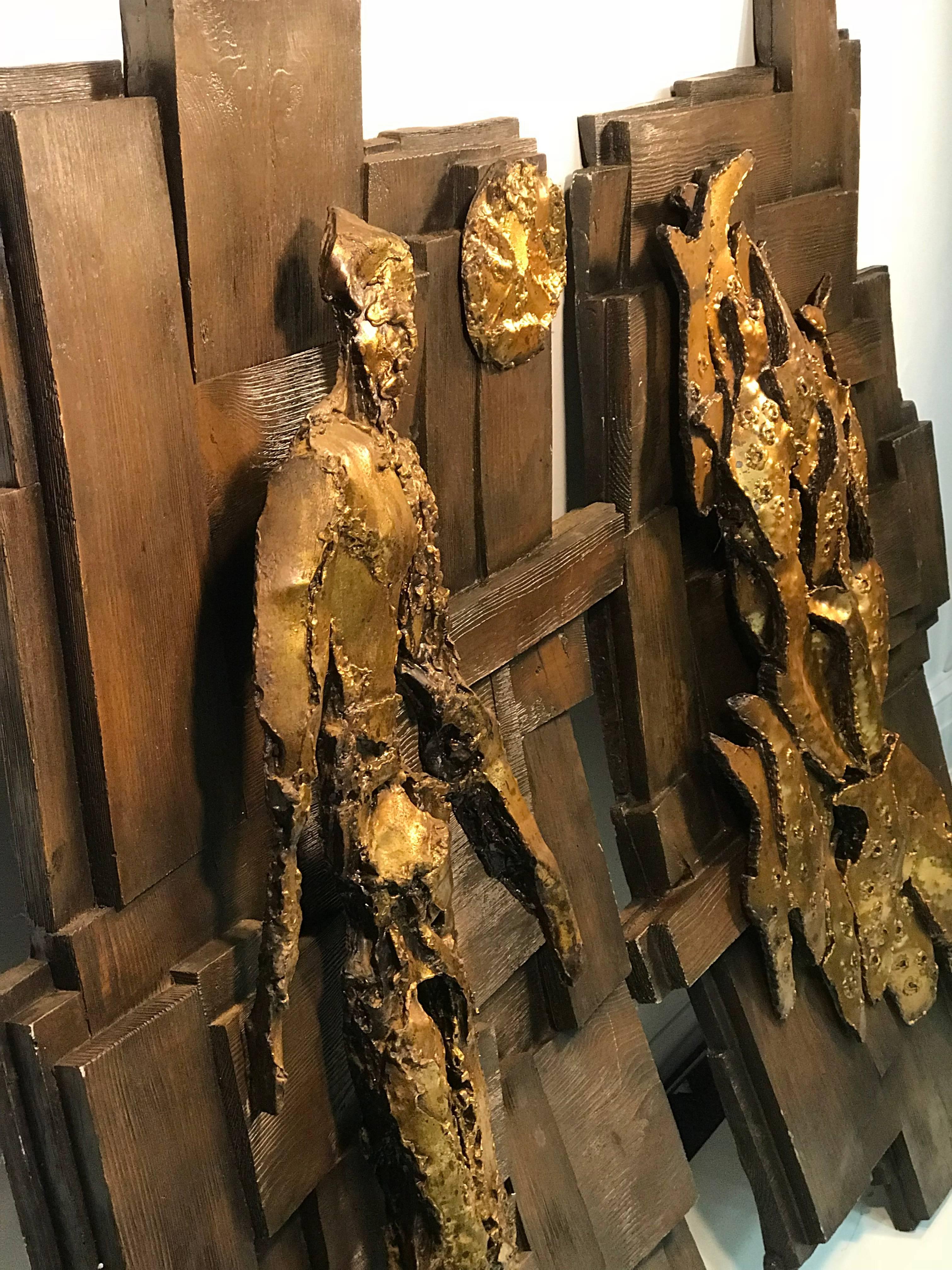 Pair of 1960s-1970s Brutalist resin wall sculptures with a deep bronze background and gilded brass toned figures. One wall sculpture features a abstract nude man with the sun in the sky. The other wall sculpture features a stylized cluster of fish.