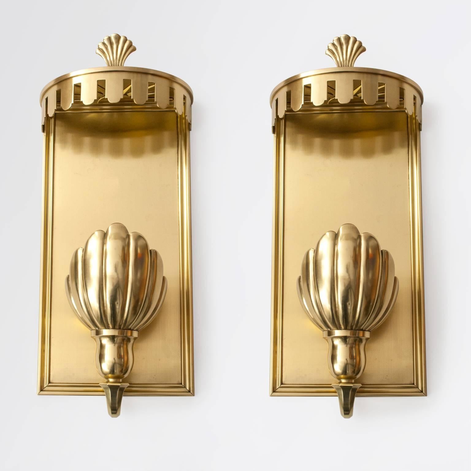 Very fine and large pair of polished brass sconces which embody the restrained elegance of what the French press described as 