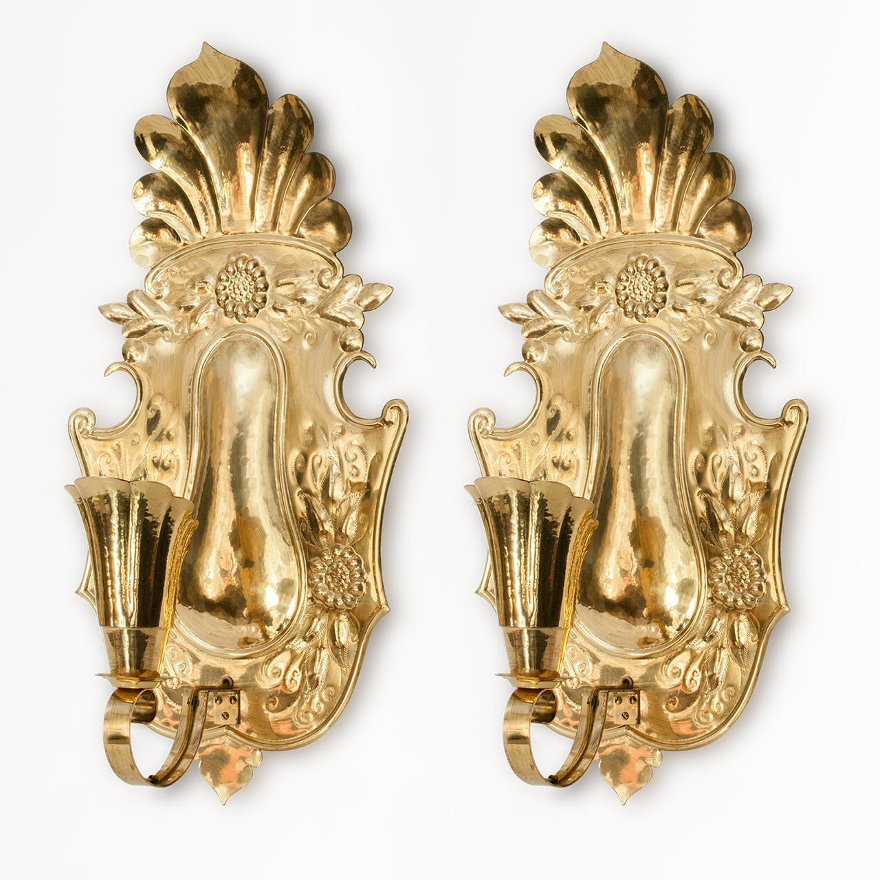 Large pair of Swedish early 20th century hammered brass wall sconces. Inspired by the Swedish Baroque the sconces have stylized shell shaped shades which hold standard base sockets. Measures: Height 25.5