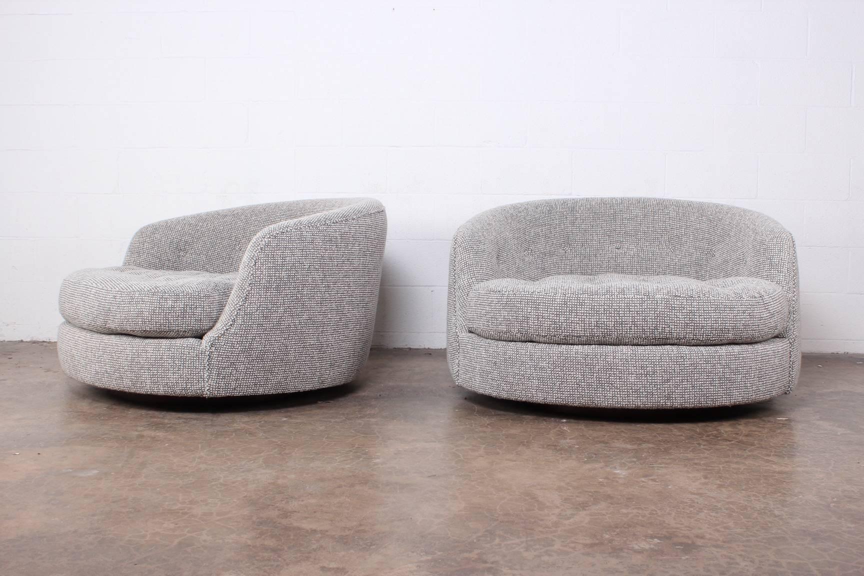 A pair of oversized swivel chairs on walnut bases newly upholstered in Maharam pebble wool. Designed by Milo Baughman for Thayer Coggin.