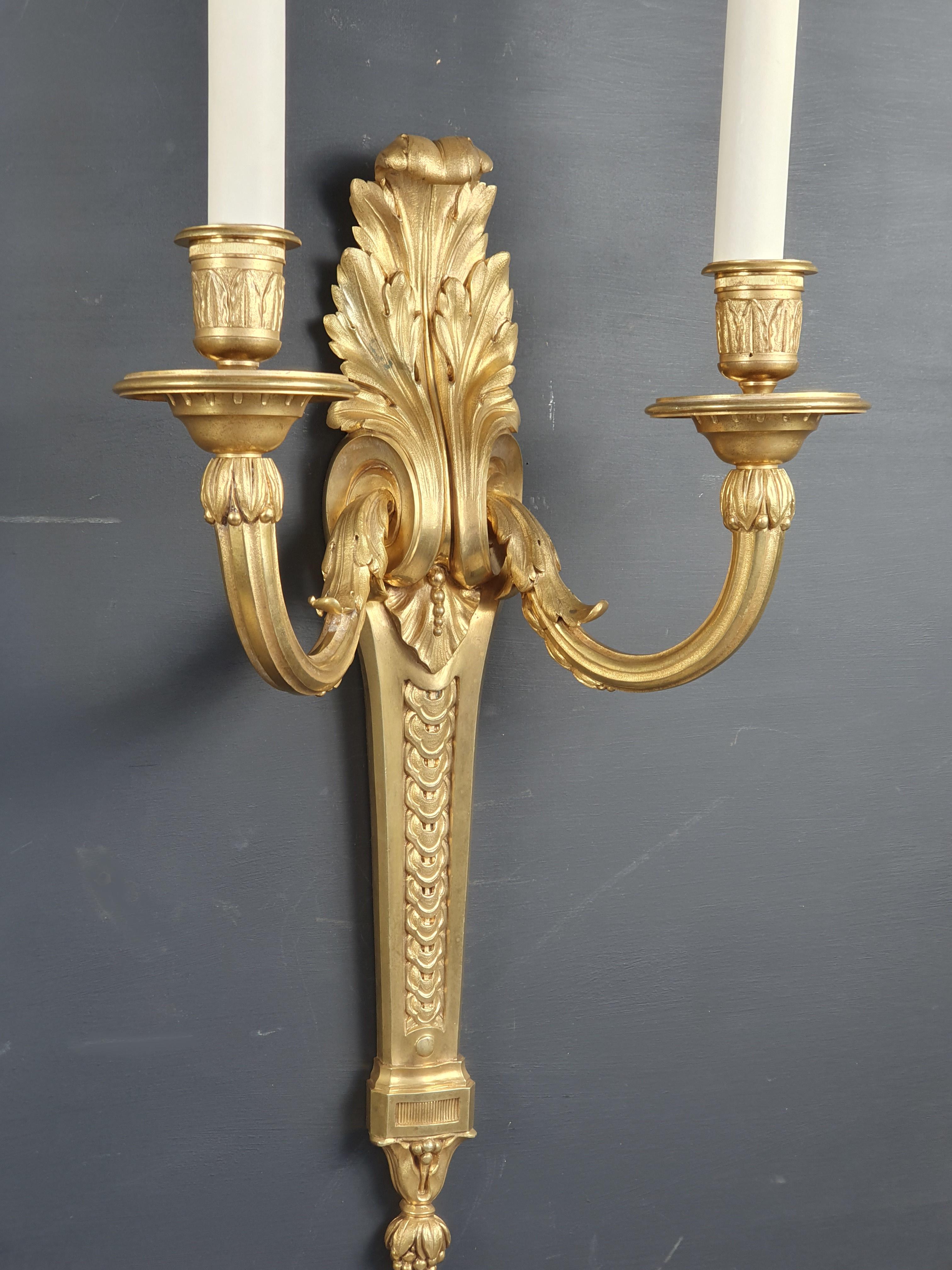 Large pair of Transition style sconces in finely chiseled gilt bronze decorated with scrolls of acanthus leaves, interlacing frieze and plant ornaments.

Beautiful original gilding in very good condition.

Parisian work from the end of the 19th