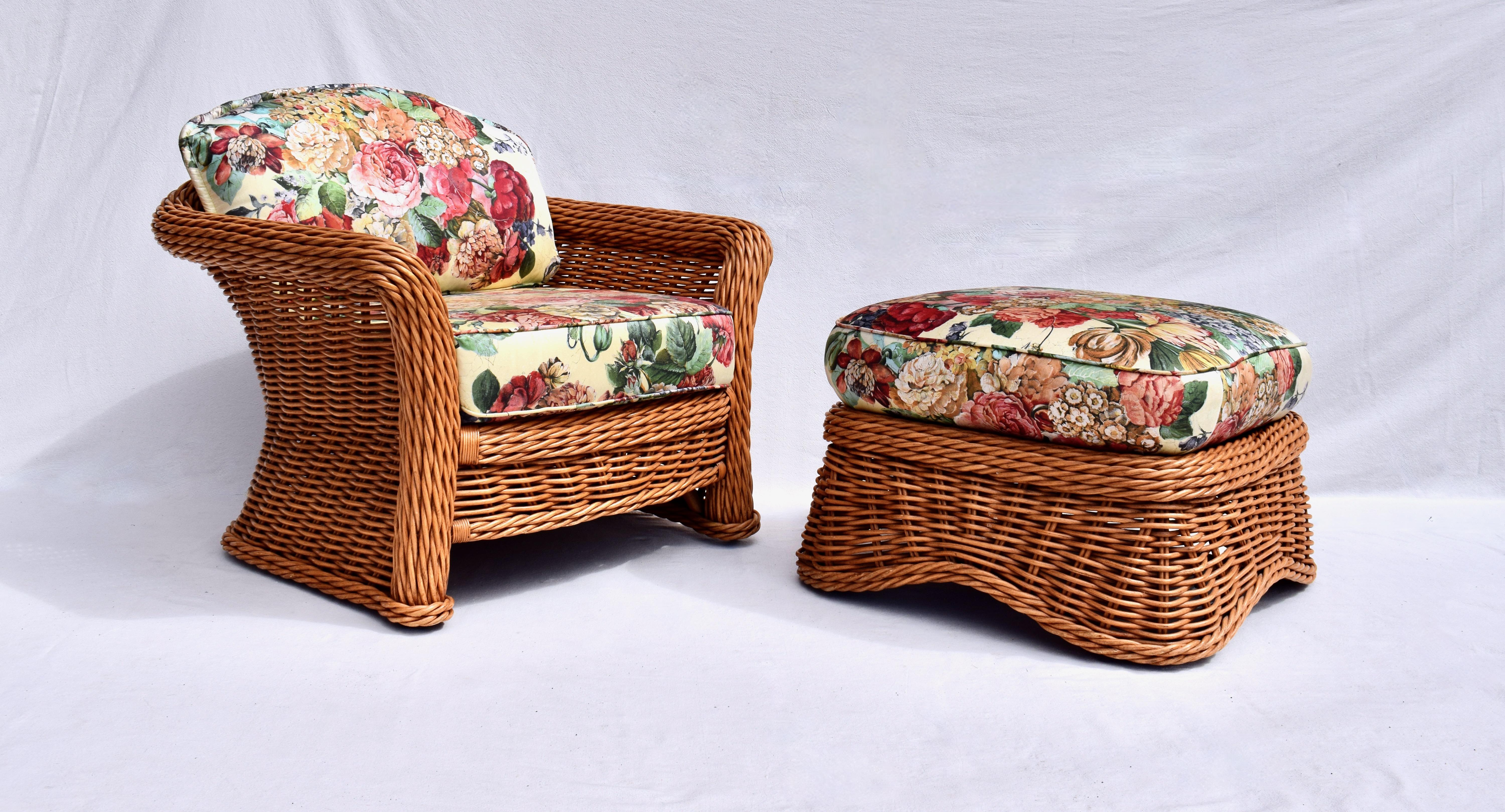 A pair of 1980s Ficks Reed rattan / reed wicker arm chairs with matching ottoman featuring new custom cushions upholstered in vibrant floral Chintz. Substantial, generous in size & super comfortable. Aesthetically pleasing from every angle with