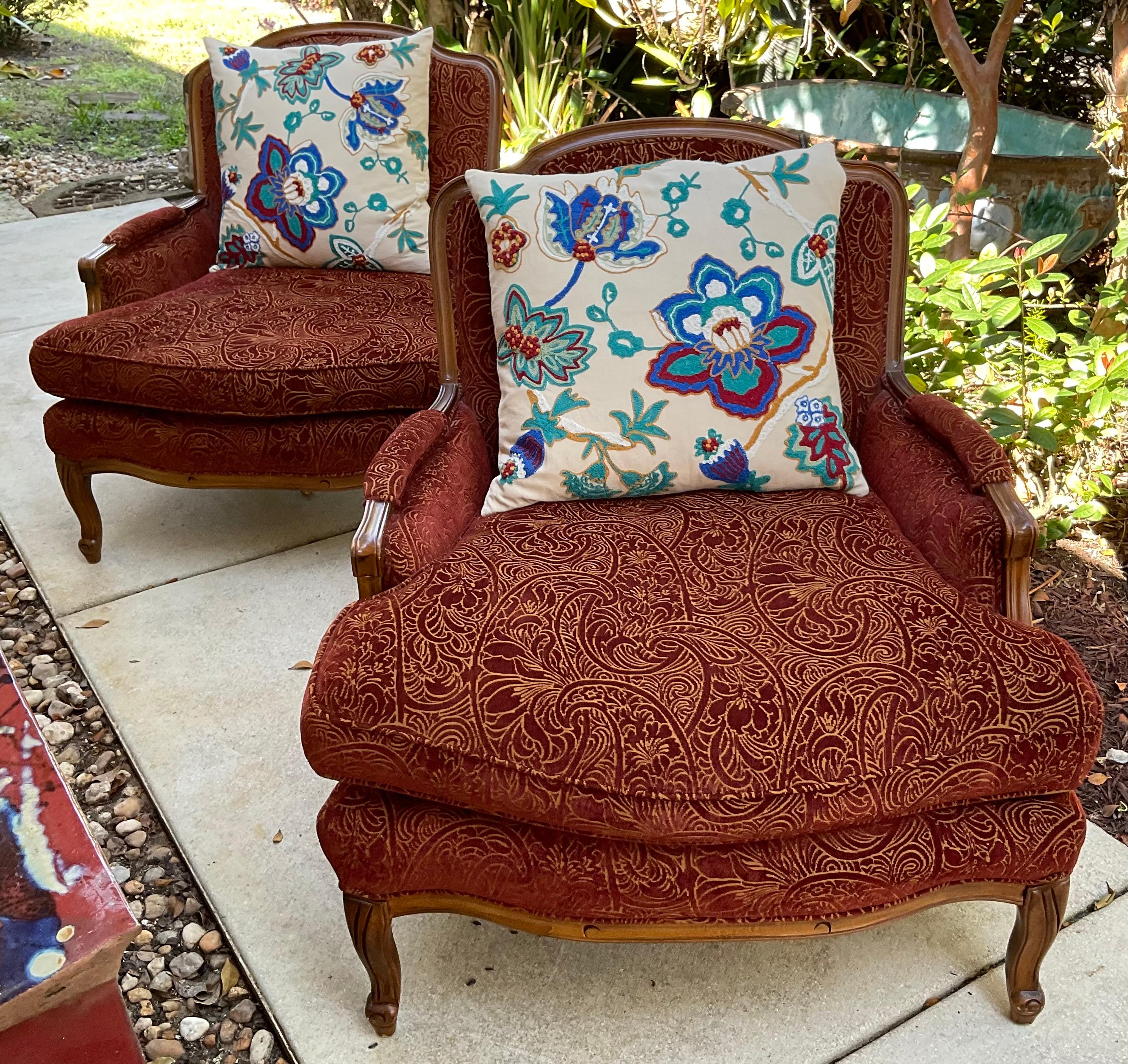 Paar hochwertige, handgeschnitzte Sessel aus Vintage-Holz, französischer Stil, tiefe, übergroße Sitze, gepolstert mit Damast-Stoff. 
Zwei hochwertige große Suzani-Kissen inklusive.