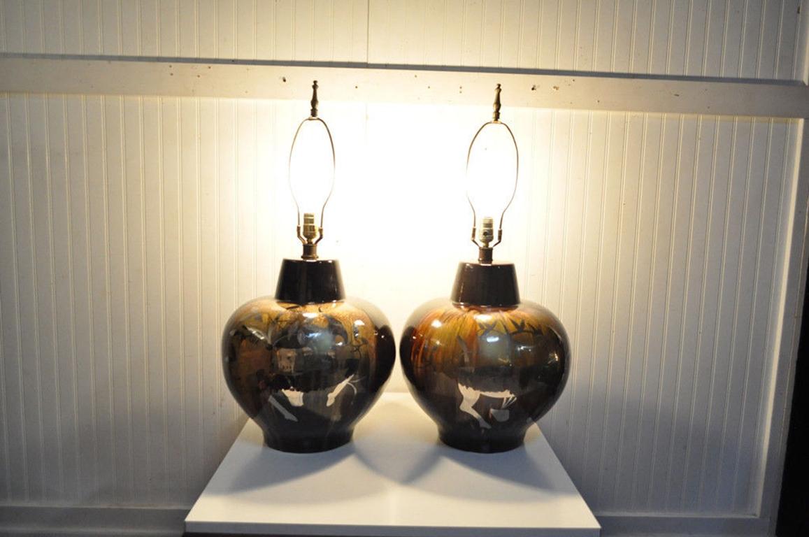 Pair of beautiful vintage Mid-Century Modern oversized drip glaze art pottery table lamps. The pottery form is very detailed and highly decorative with huge silvered gazelles or rams on both sides of each lamp. Both lamps are wired for 3-way bulbs.
