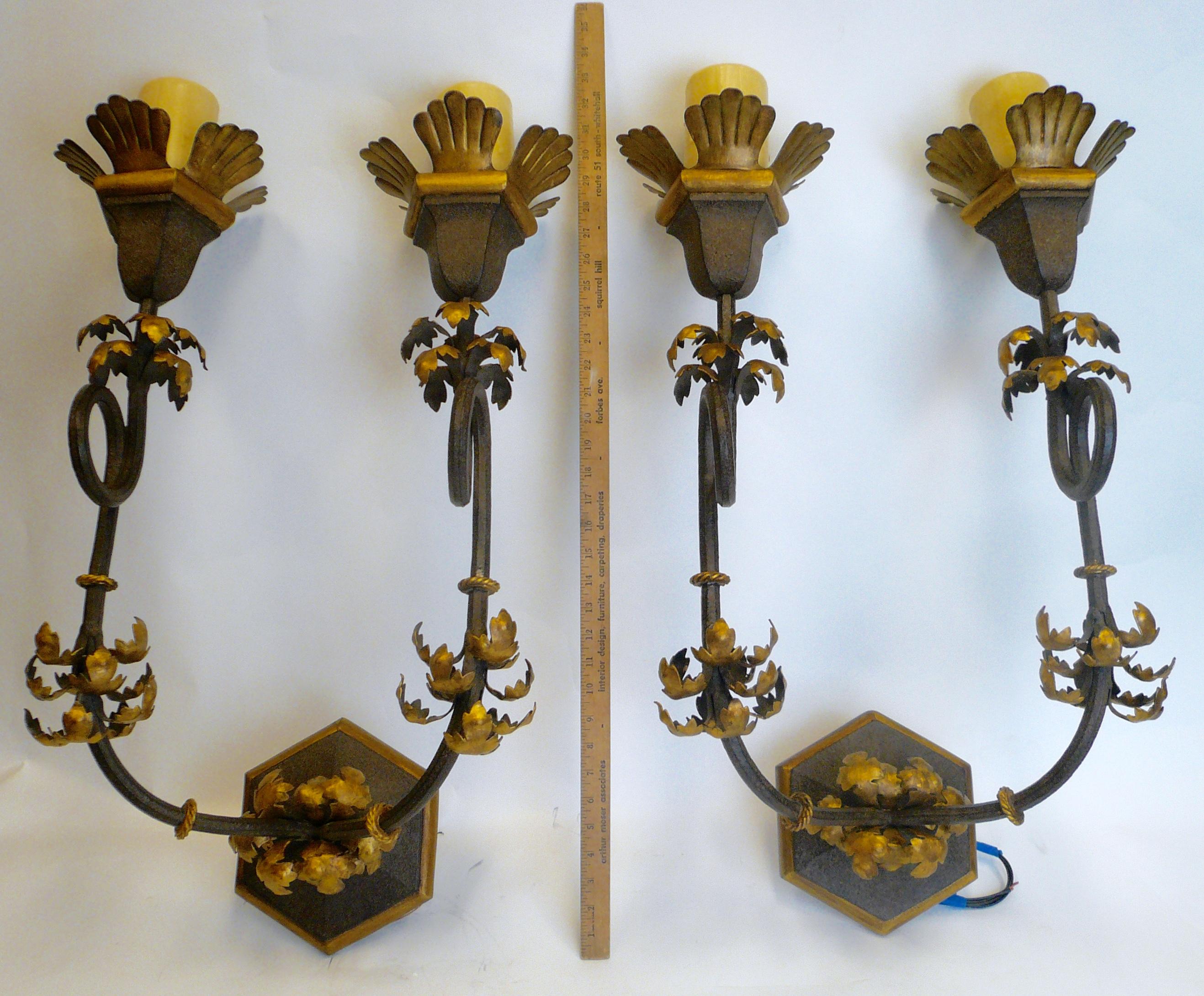 These impressive pair of hand forged wrought iron sconces feature
carved and hand painted hardwood backs, and gilded highlights.
They were purchased new from Gregorius Pineo (the trade price was over $4,000.00 each), and have never been used!