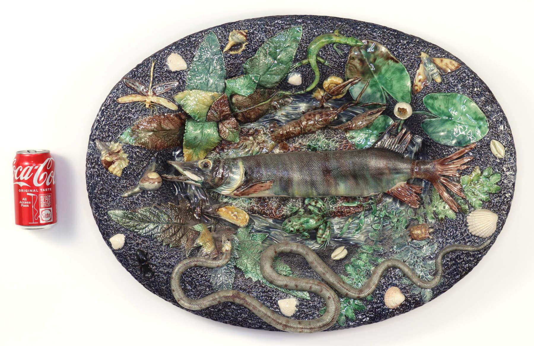 Large and elaborate Palissy ware platter, attributed to the factory of Victor and Achille Barbizet. The long fish, probably a pike, surrounded by plants, insects and amphibians. Plants include ferns and a water lily; insects include a dragonfly,