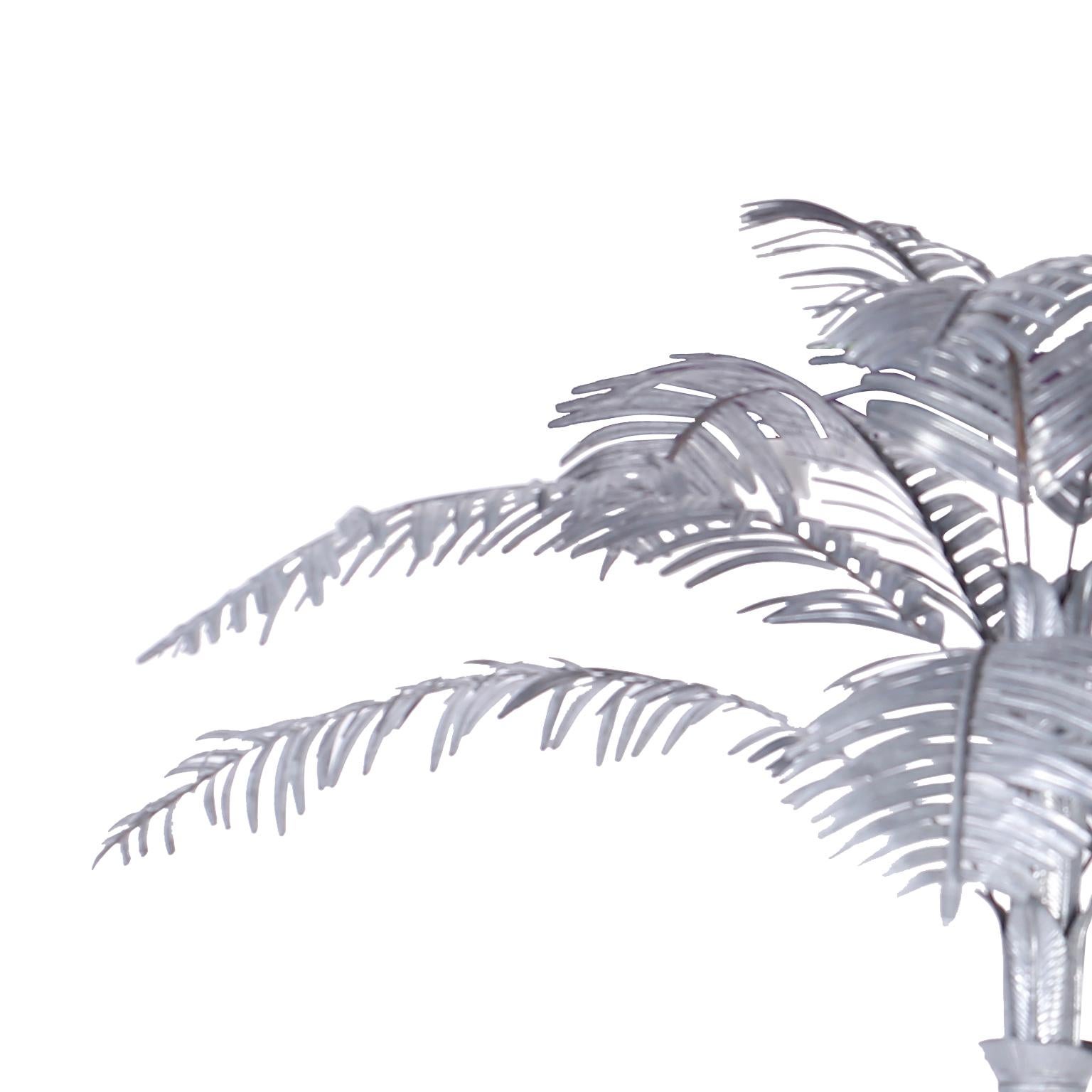 An impressive life-size palm tree sculpture crafted in galvanized metal with twelve removable palm fronds, stylized trunk, and a round weighted base.
