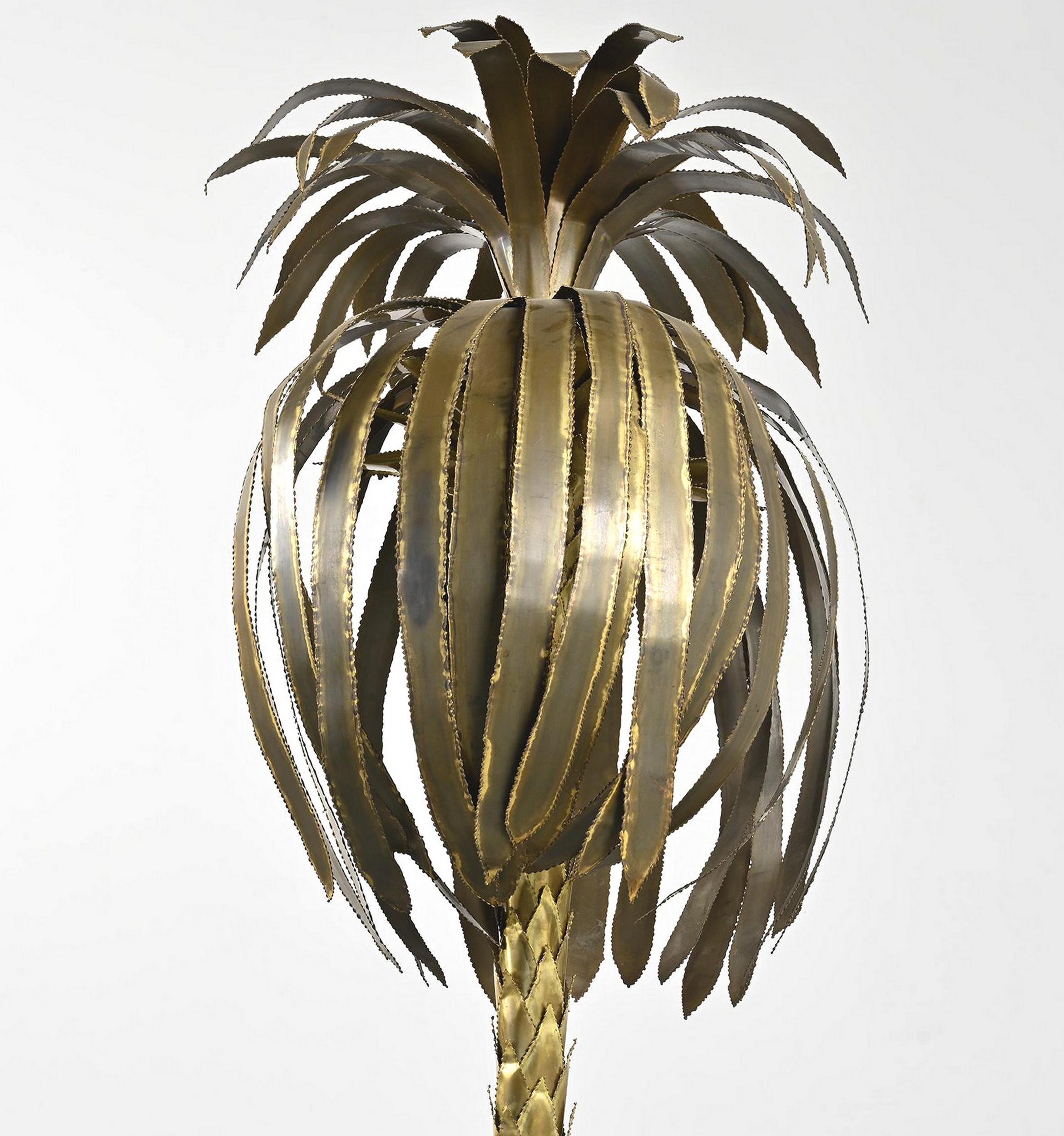 Lámpara de pie con forma de palmera, diseñada por Christian Techoueyres para la Maison Jansen en la década de 1970.
Gran lámpara de pie escultórica de latón cortado, moldeado y soldado a mano, colocada en una jardinera de madera laminada