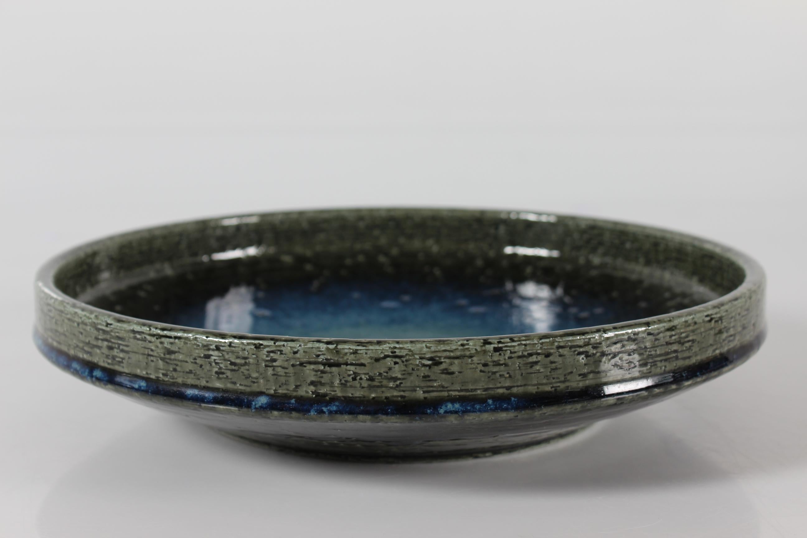 Large low ceramic bowl by Annelise and Per Linnemann-Schmidt for Palshus, Denmark. Made in the 1960s.
It is made with chamotte clay which gives a rough and vivid surface. The glossy glaze is a deep blue and moss green.

The bowl is fully marked