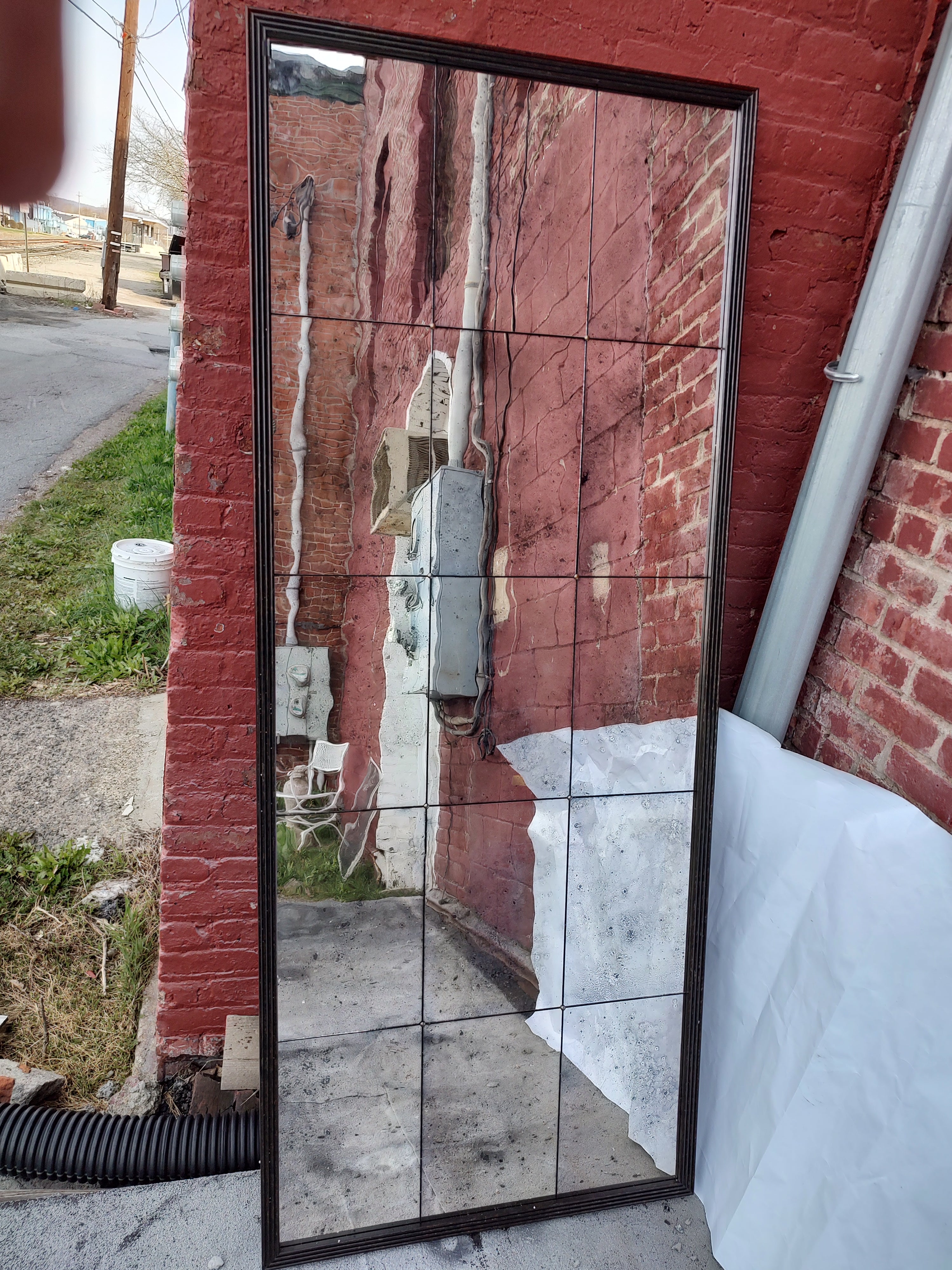 Fabulous segmented tall mirror with 15 panels of hand distressed mirror on board. Framed in a mottled carved ribbed wood frame. Can be hung in either direction. Was in the Donghia showroom in NYC. In excellent vintage condition with minimal wear.