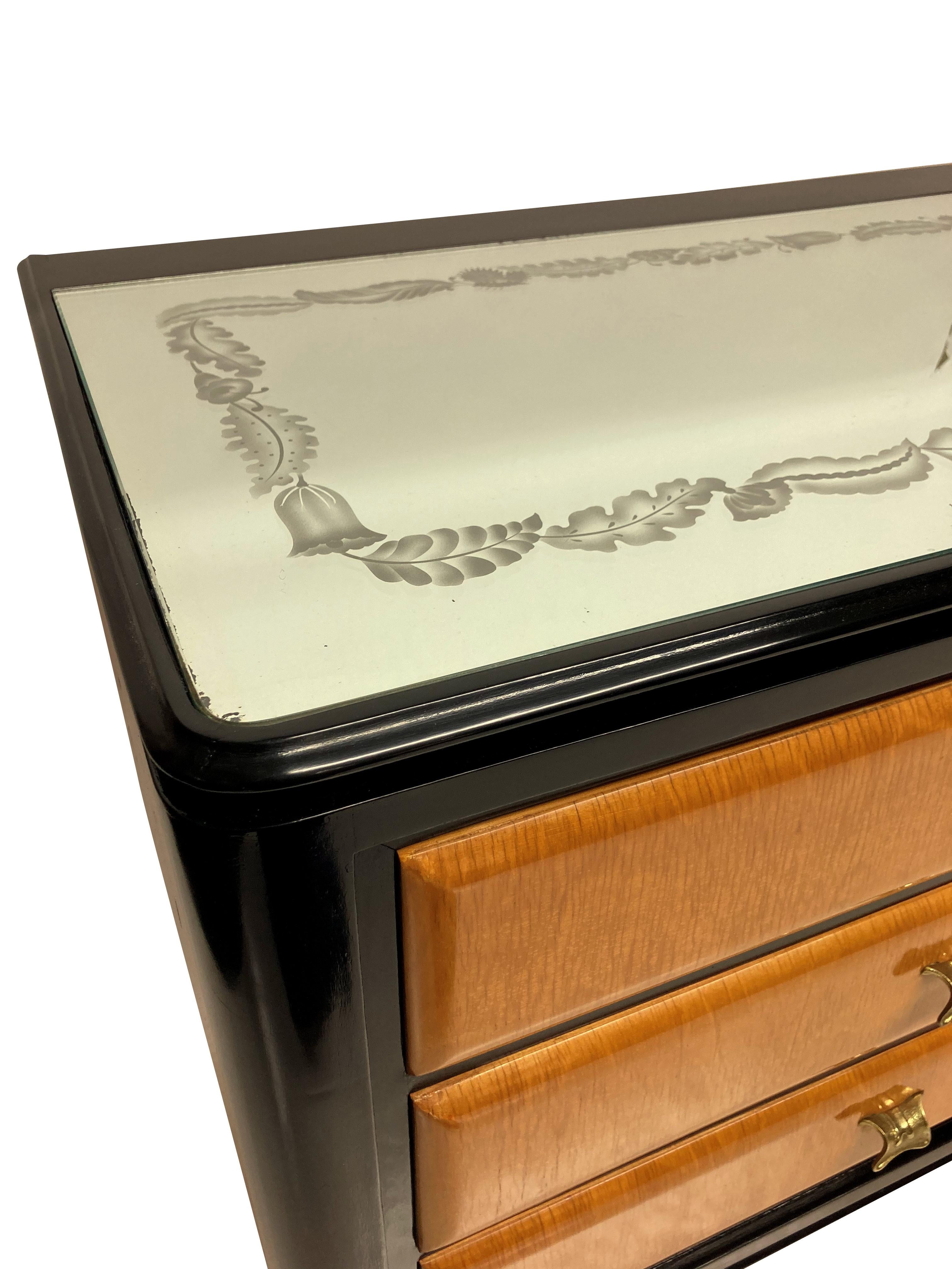 A large Italian credenza by Paolo Buffa in black lacquer, with lemon wood drawers. With nine drawers in total, each with a gilt brass handle, bras sabot feet and a mirror top with foliate etched border.