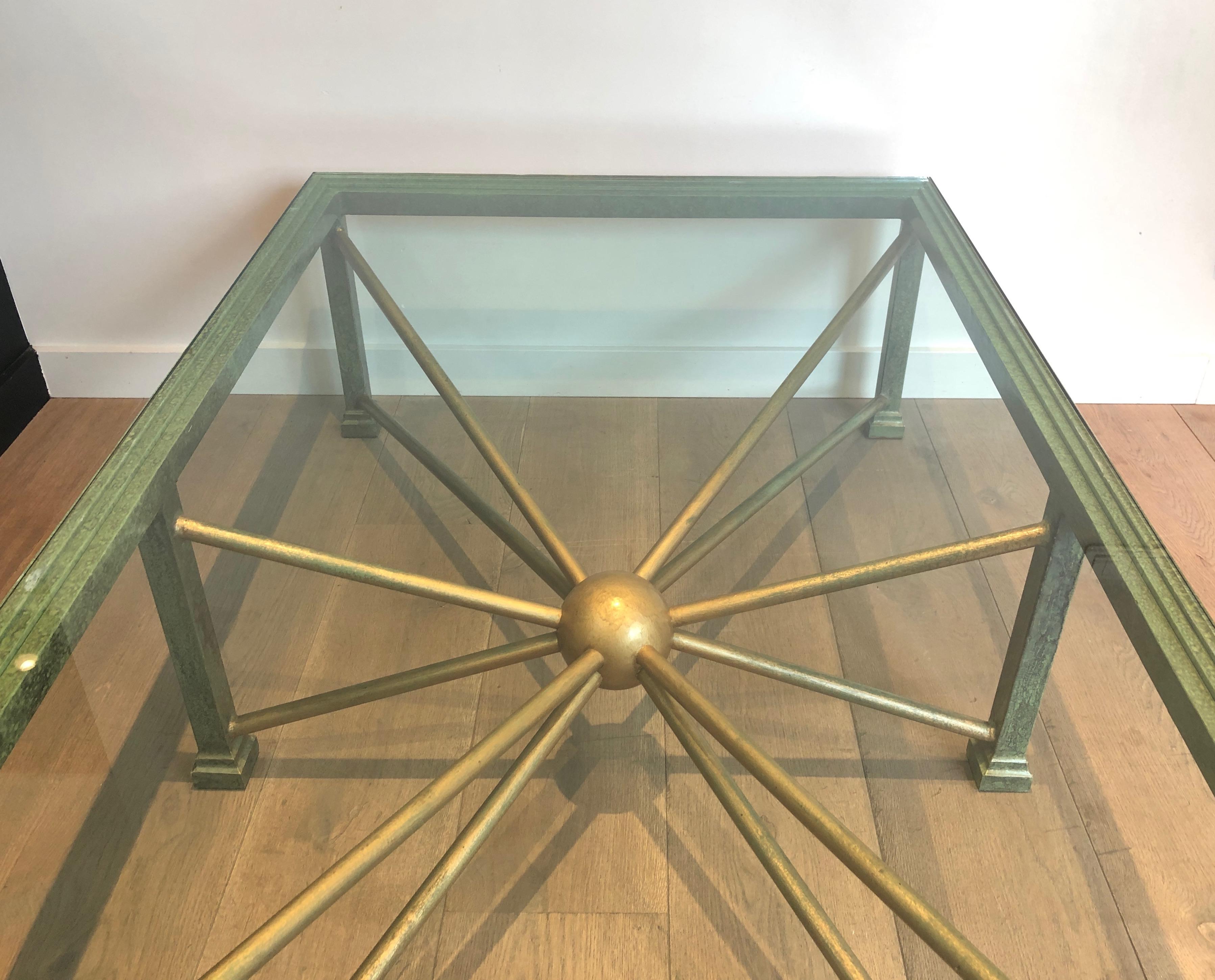 This large and heavy coffee table is made of patinated and gilt steel and wrought iron. This is a French work, circa 1940.