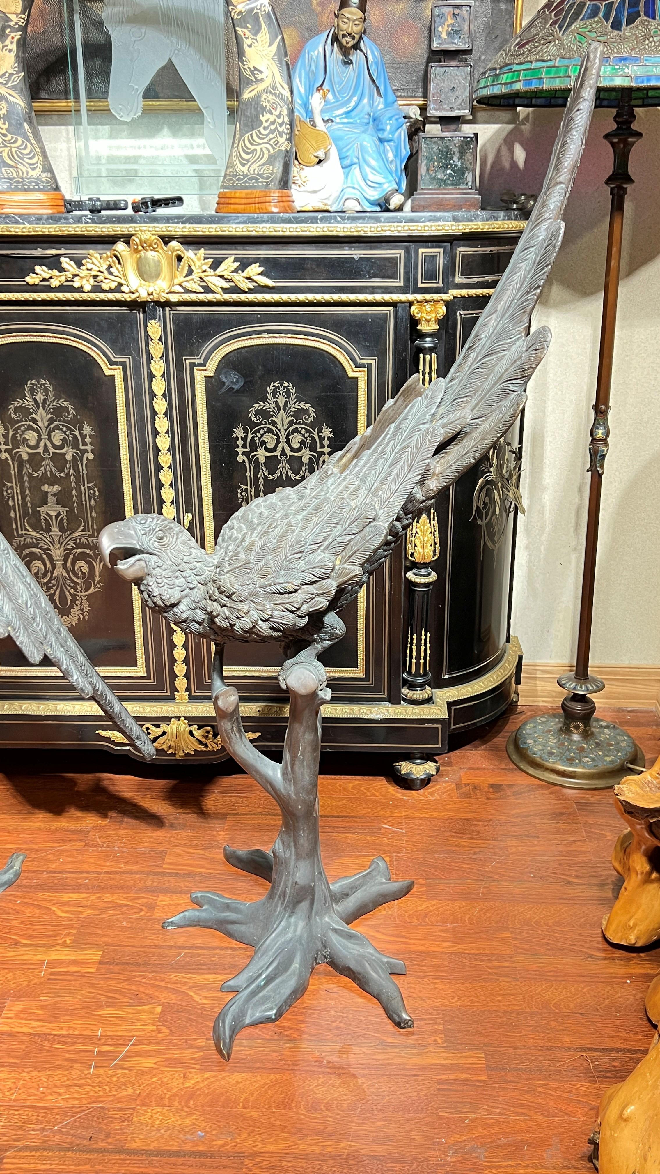 Très grande sculpture en bronze d'époque milieu de siècle représentant un perroquet perché sur une branche d'arbre d'après Jules Moigniez (1835-1894), mesurant approximativement 48 par 24 par 12 pouces.  Apparemment non signé.