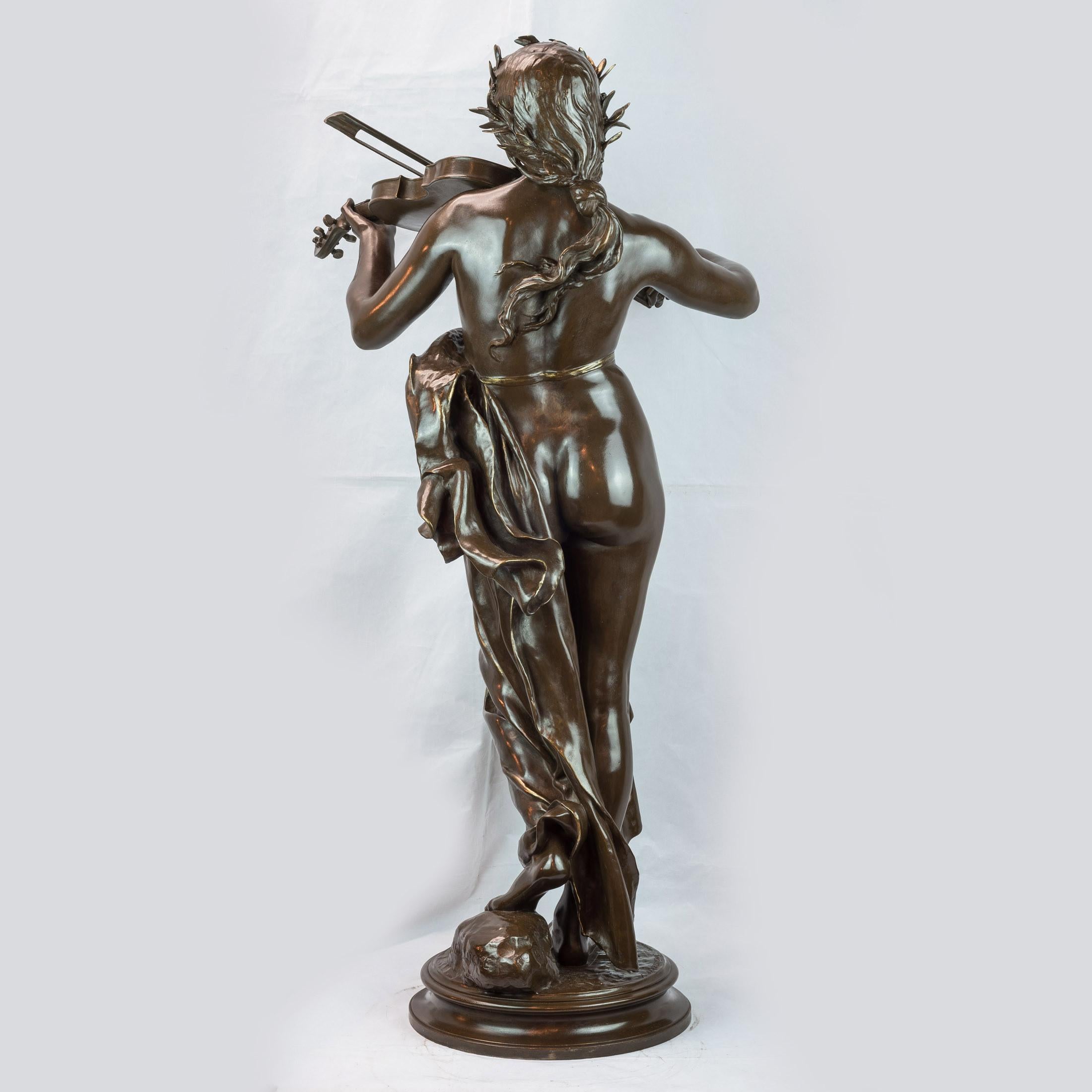 A large patinated bronze sculpture of a woman playing a violin 