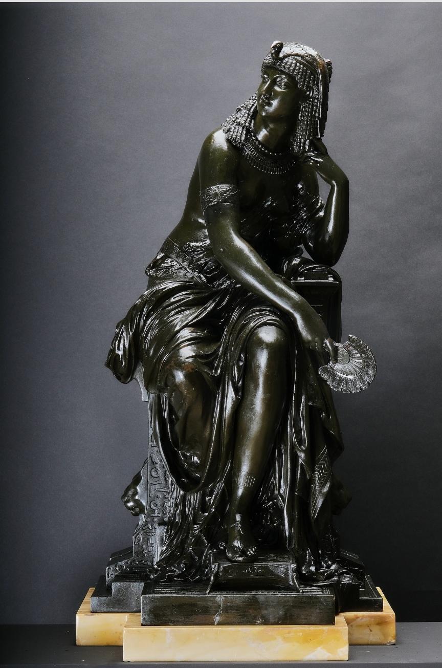 
Large patinated bronze statue of Cleopatra, Attr. Mathurin Moreau (1822 Dijon - 1912 Paris) Bronze, dark patina. Ocher colored marble base. Cleopatra seated on a throne with stylized hieroglyphics and half-naked lion head masks in a pensive pose,