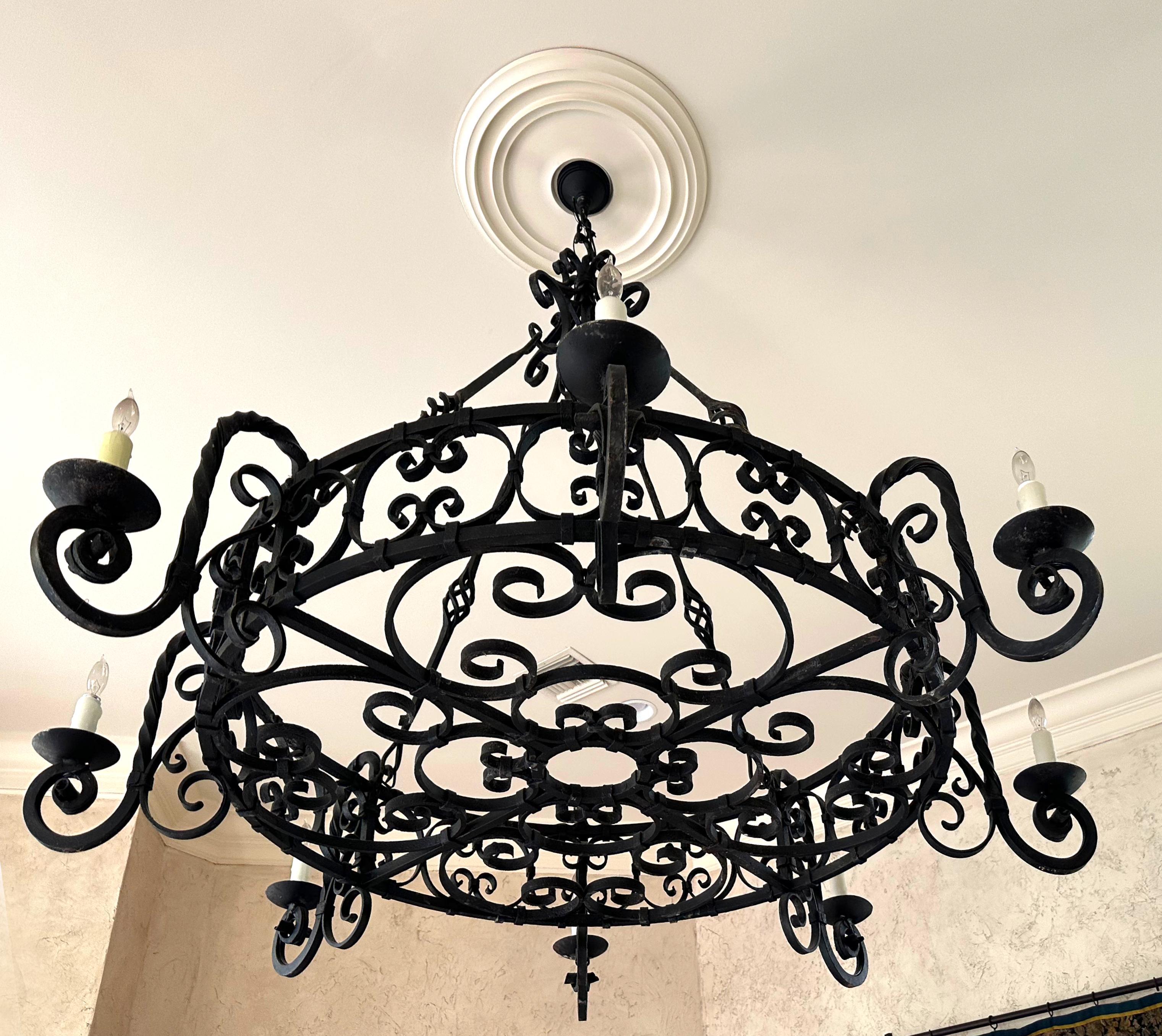 
Large Patinated Wrought Iron Eight-Light Circular Chandelier 
The circular body with inset scrolls and curved arms hung from four rods.
Height 60 in. (152.4 cm.), Diameter (approx) 72 in. (182.88 cm.)