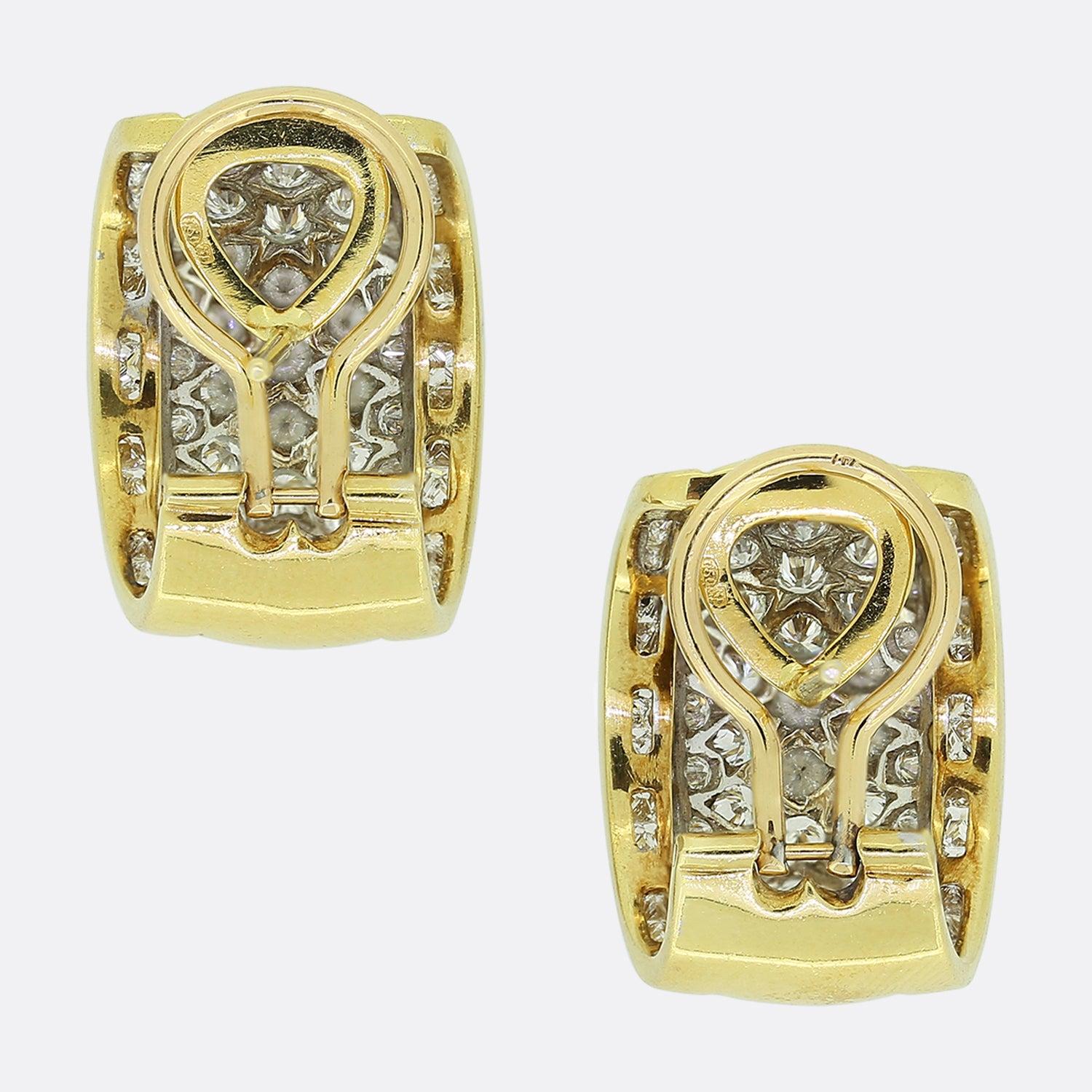 Ecco uno splendido paio di orecchini con diamanti incastonati. Ogni pezzo è disegnato in modo avvolgente e mostra una formazione a linea singola di diamanti taglio princess su ogni bordo esterno. Queste pietre incastonate fungono da bordo per la
