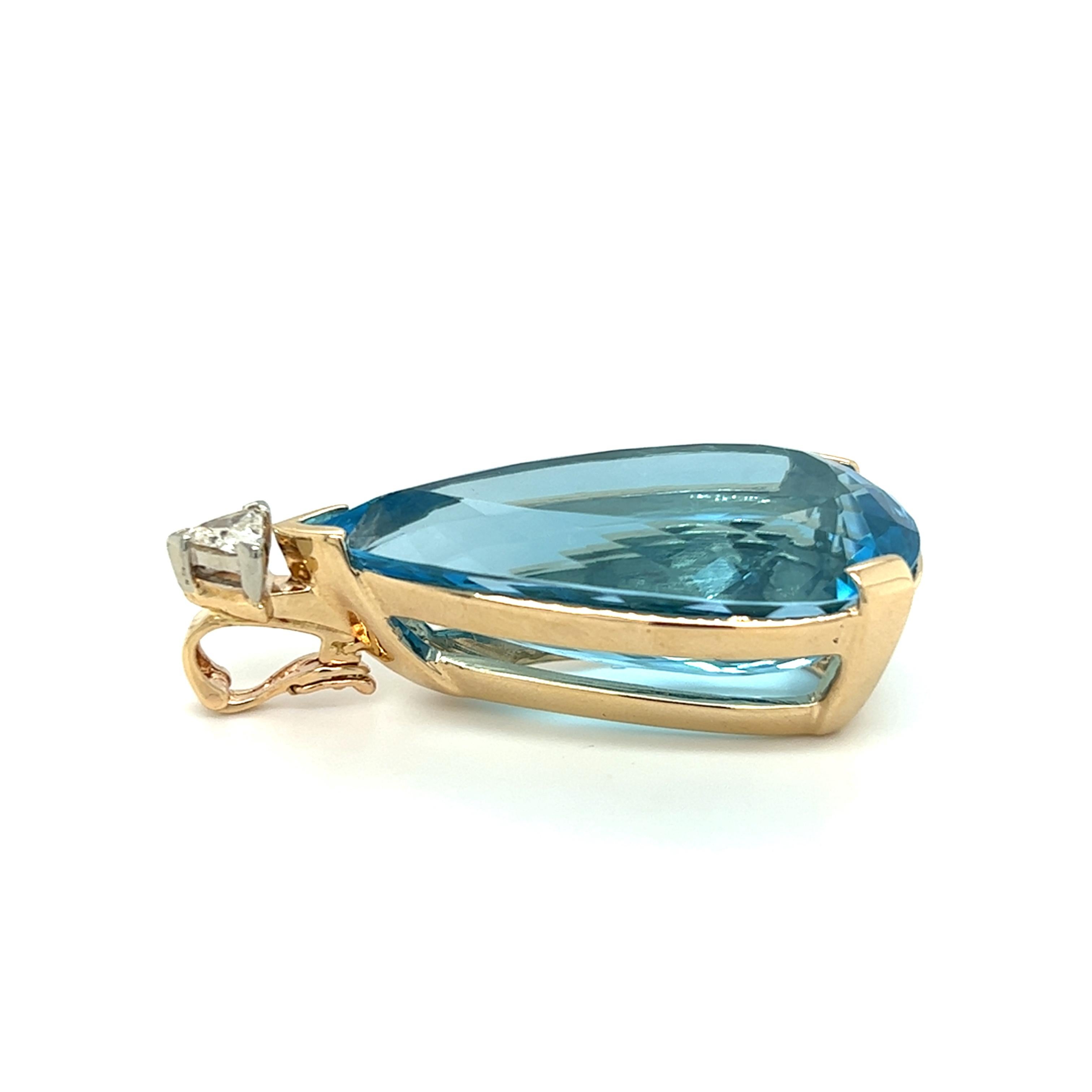 One large 14 karat yellow gold (stamped 14K) enhancer pendant, set with one (1) pear shaped blue topaz measuring approximately 1 1/3x1/2 inches and one 5mm triangle cut diamond, approximately 0.20 carat with I/J color and I1 clarity.
The pendant