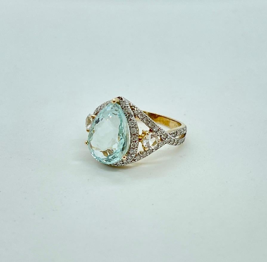 Wir glauben, Sie werden diesen BIG und einzigartigen Kleiderring lieben!
Er ist mit einem großen, birnenförmigen, 7,08ct natürlichen Aquamarin besetzt, der mit Diamanten und 'Goshenite' Beryll in 9ct Gelbgold gefasst ist.
Der Aquamarin ist sehr