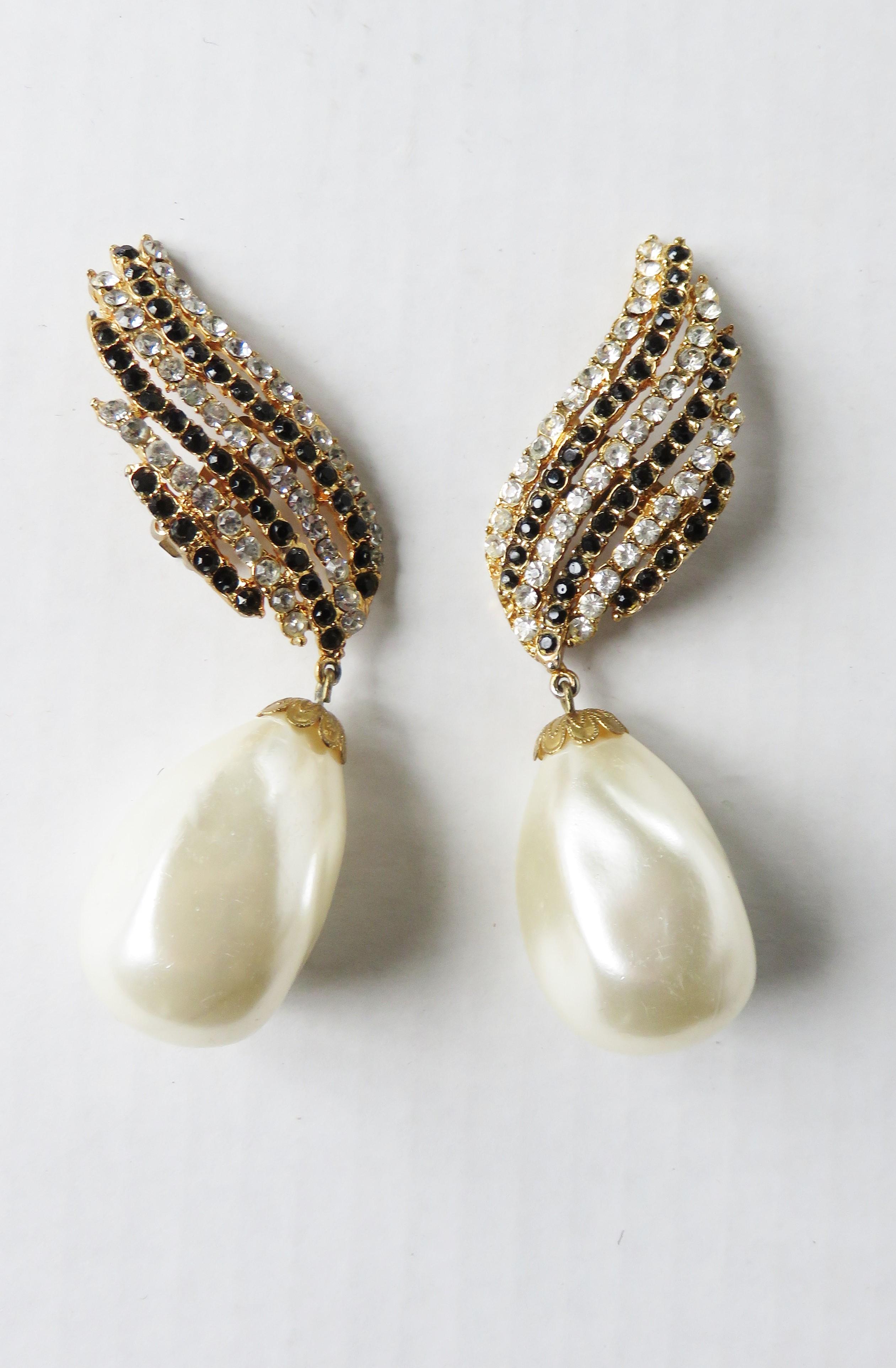 Fabulous alternately red and clear rows of crystals winged clip on earrings with a giant faux pearl dangles from 1983.  Worn on a Cosmopolitan Cover by model Paulina Poritzcova and Diana Vreeland. 

Pearl  1.50