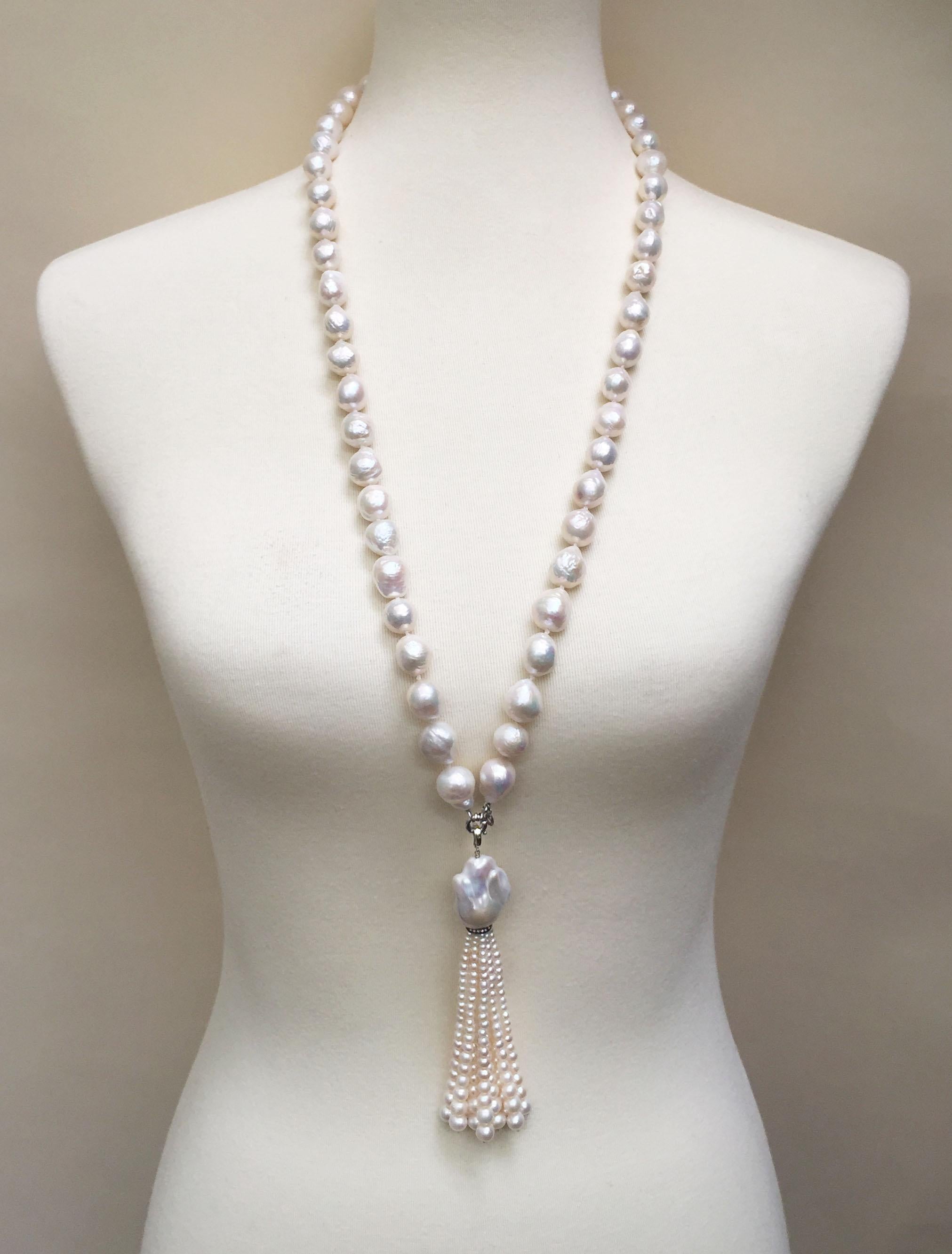 This large pearl necklace with pearl and diamond tassel and 14 k white gold clasp is made with carefully chosen 15 mm white pearls that create elegant lines going through the necklace. The tassel starts with a large baroque white pearl (28 x 21 mm),