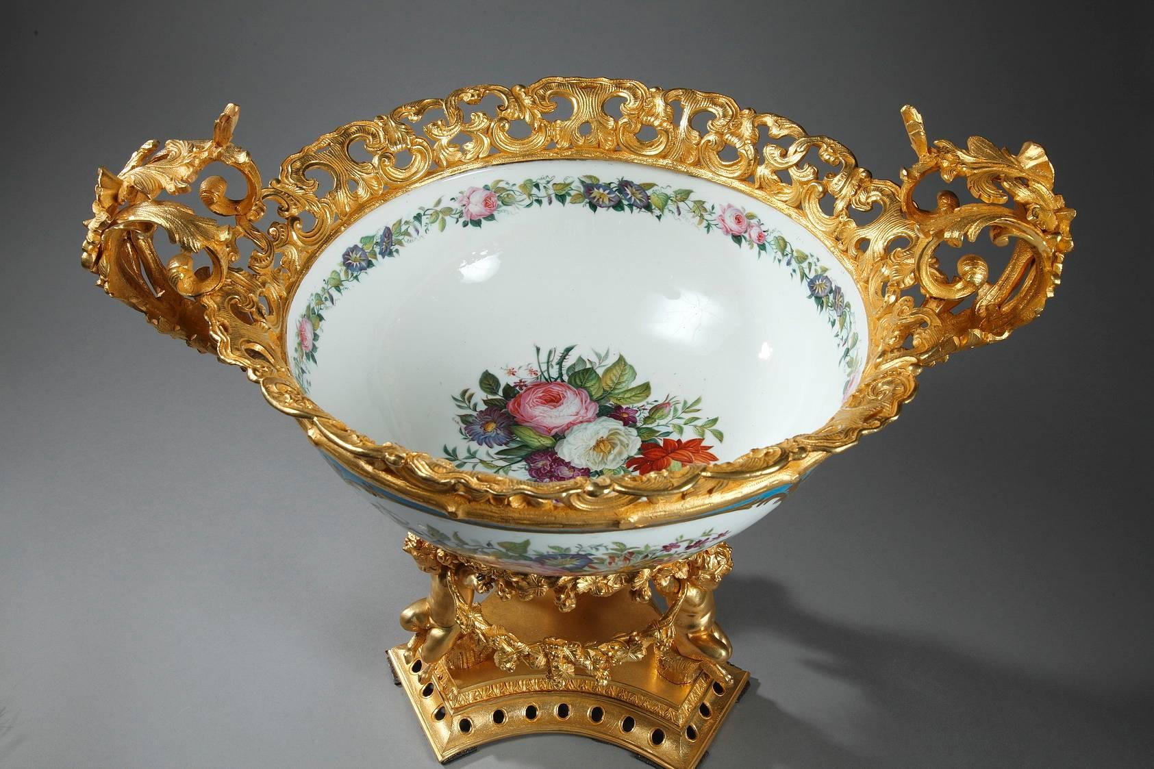 Substantial porcelain pedestal bowl embellished with white medallions set on a sky blue background. On one side of the bowl, the medallion is decorated with a pastoral scene depicting a courting couple, and on the other side, the medallion displays