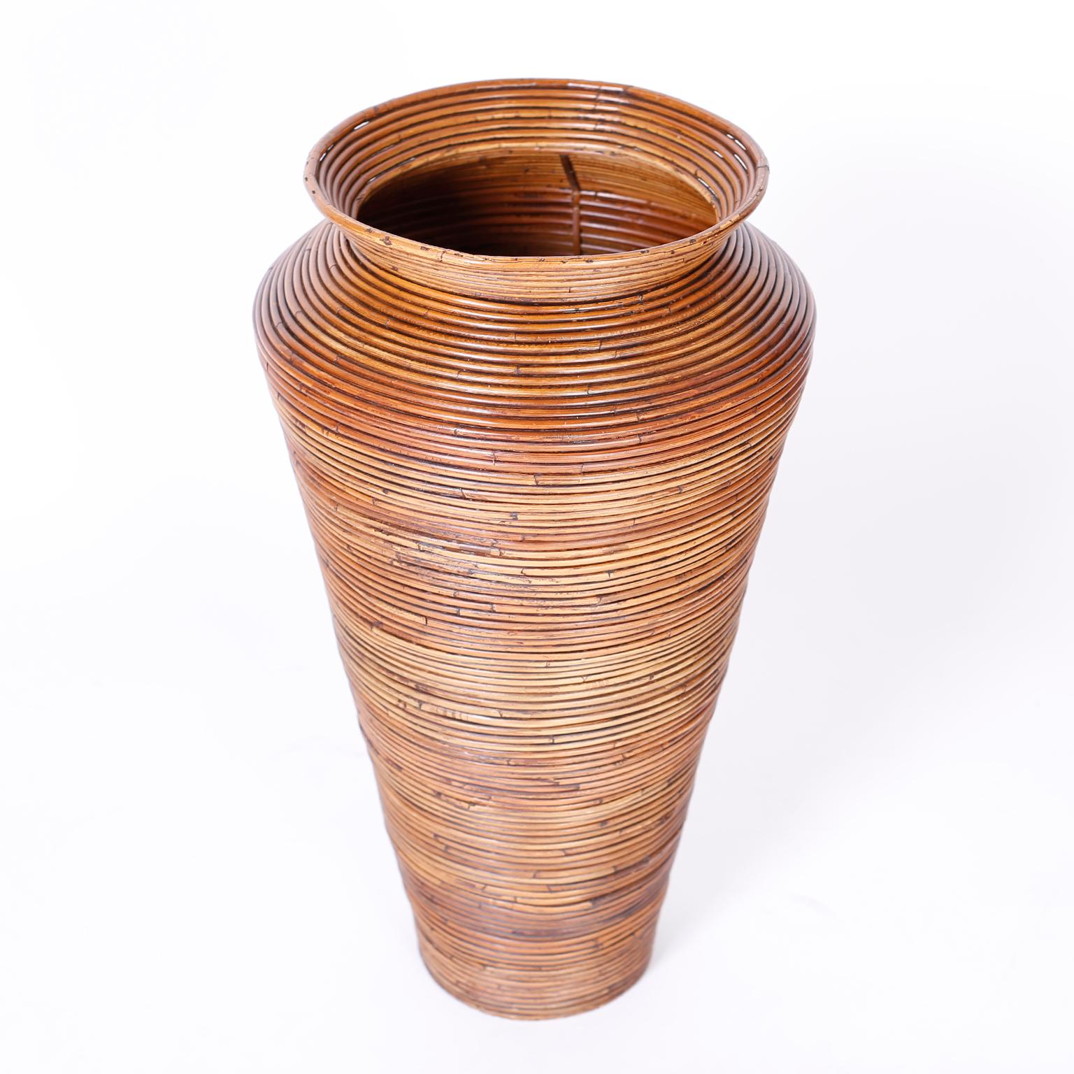 Large scale mid century faux vase crafted with pencil reed in an ingenious bending technique with a classic modern form.