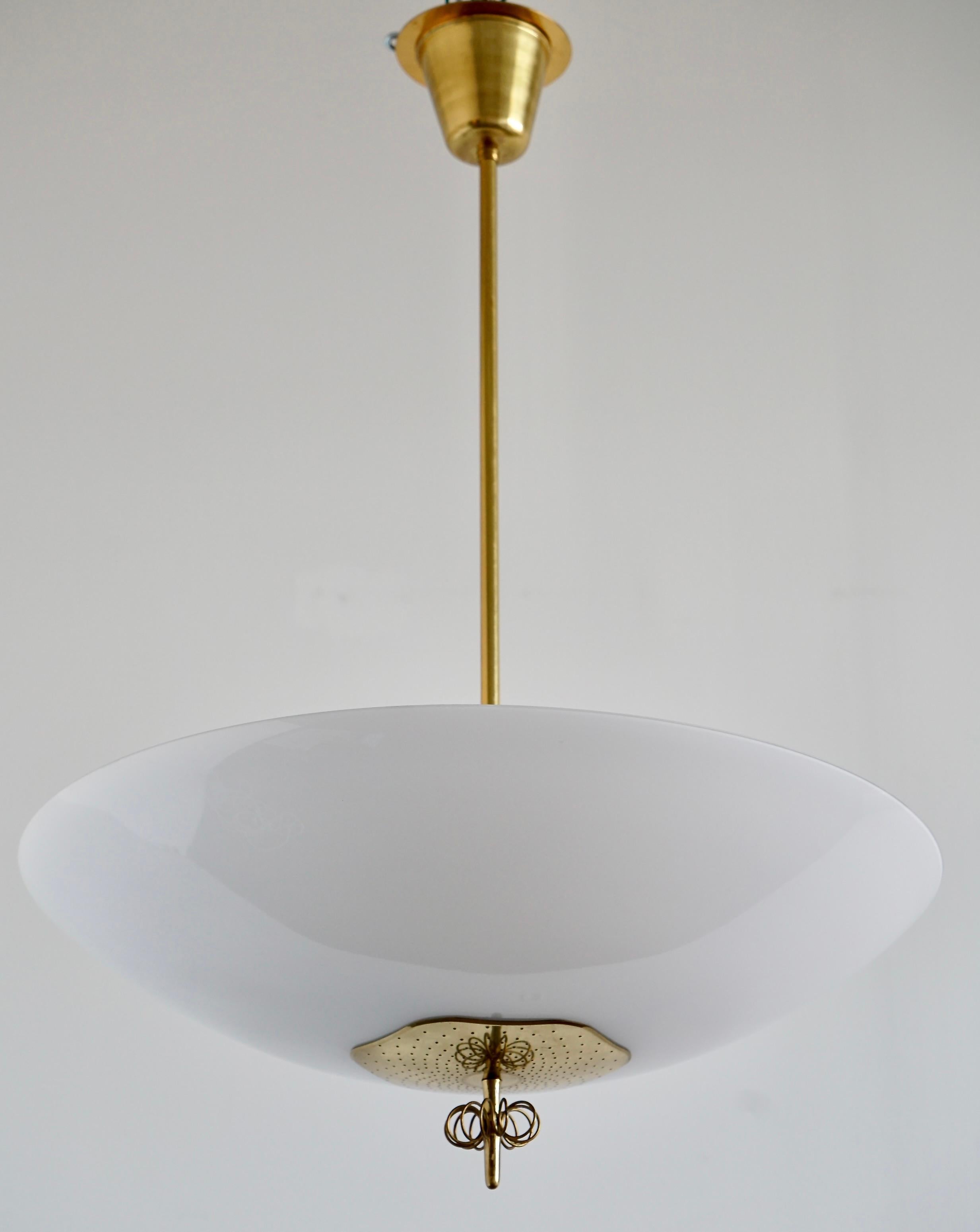 Große Pendelleuchte, entworfen von Paavo Tynell für Idman, Finnland, um 1950. Opalglasschirm mit perforierter Messingplatte und Messingdrahtdekor. Gekennzeichnet mit 