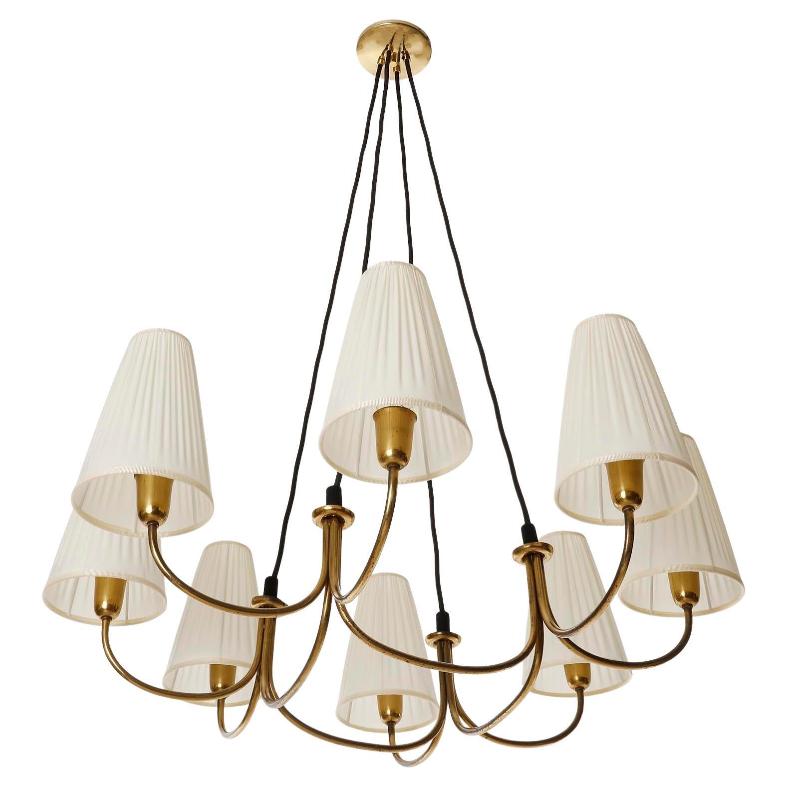 A fantastic chandelier made of brass with cream colored pleated fabric shades manufactured by Rupert Nikoll in Austria in 1950s.
The brass parts are in very good original condition with patina and have a warm aged hue.
The lamp shades are renewed.
