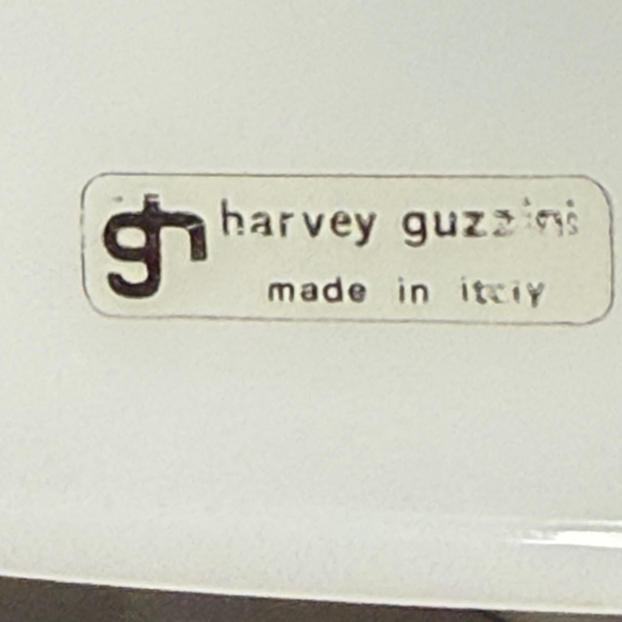 Testimonianza del design italiano degli anni '70, la lampada a sospensione Harvey Guzzini unisce innovazione e stile. Il diffusore in metacrilato bianco migliora la distribuzione della luce, producendo un bagliore caldo e ambientale adatto ad