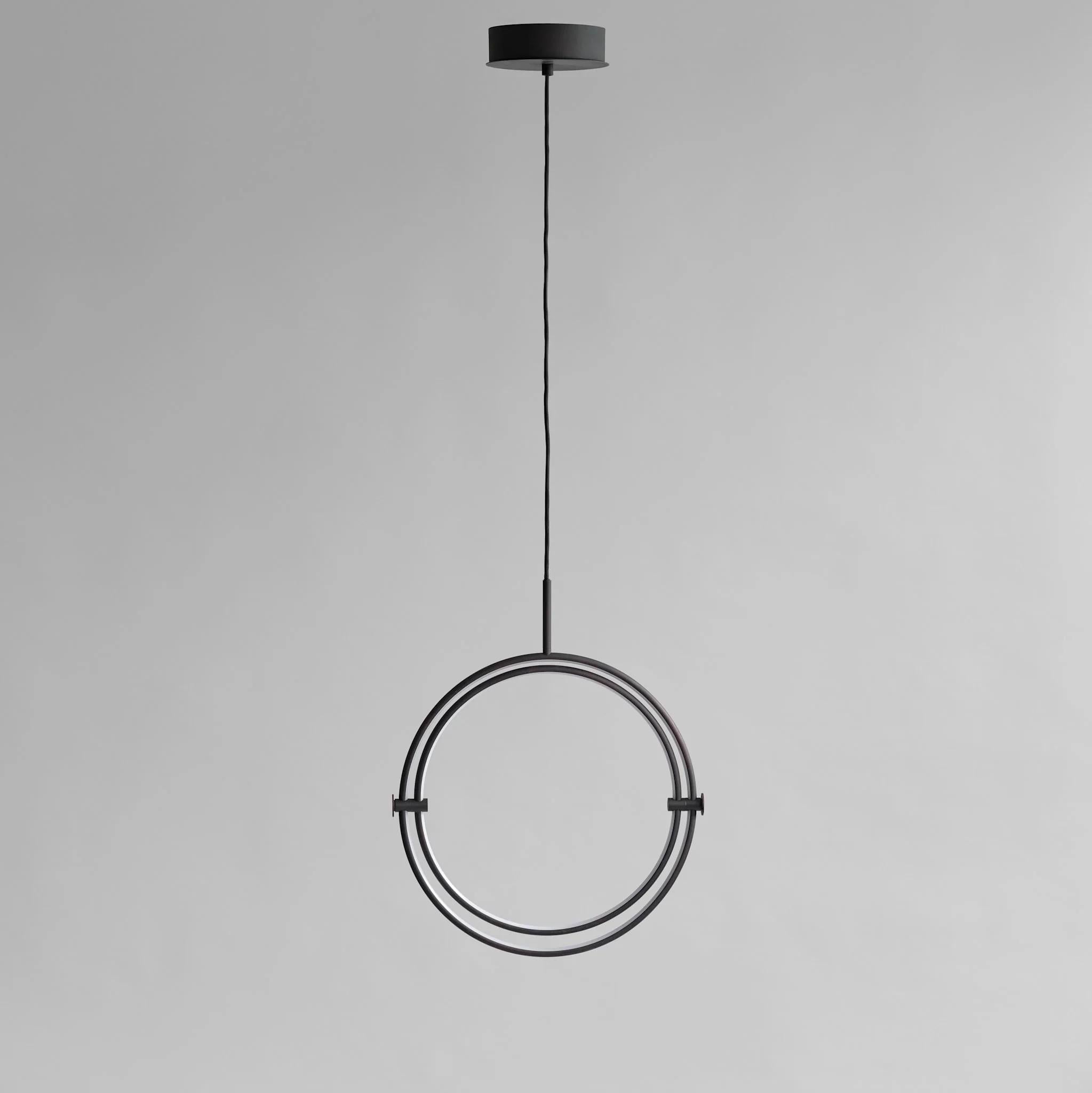 Grande lampe suspendue, finition patinée noire, métal et acrylique, œuvre d'art contemporaine.

Cette suspension se compose de deux cercles en aluminium méticuleusement conçus, chacun équipé d'une lumière LED chaude qui éclaire l'intérieur de la