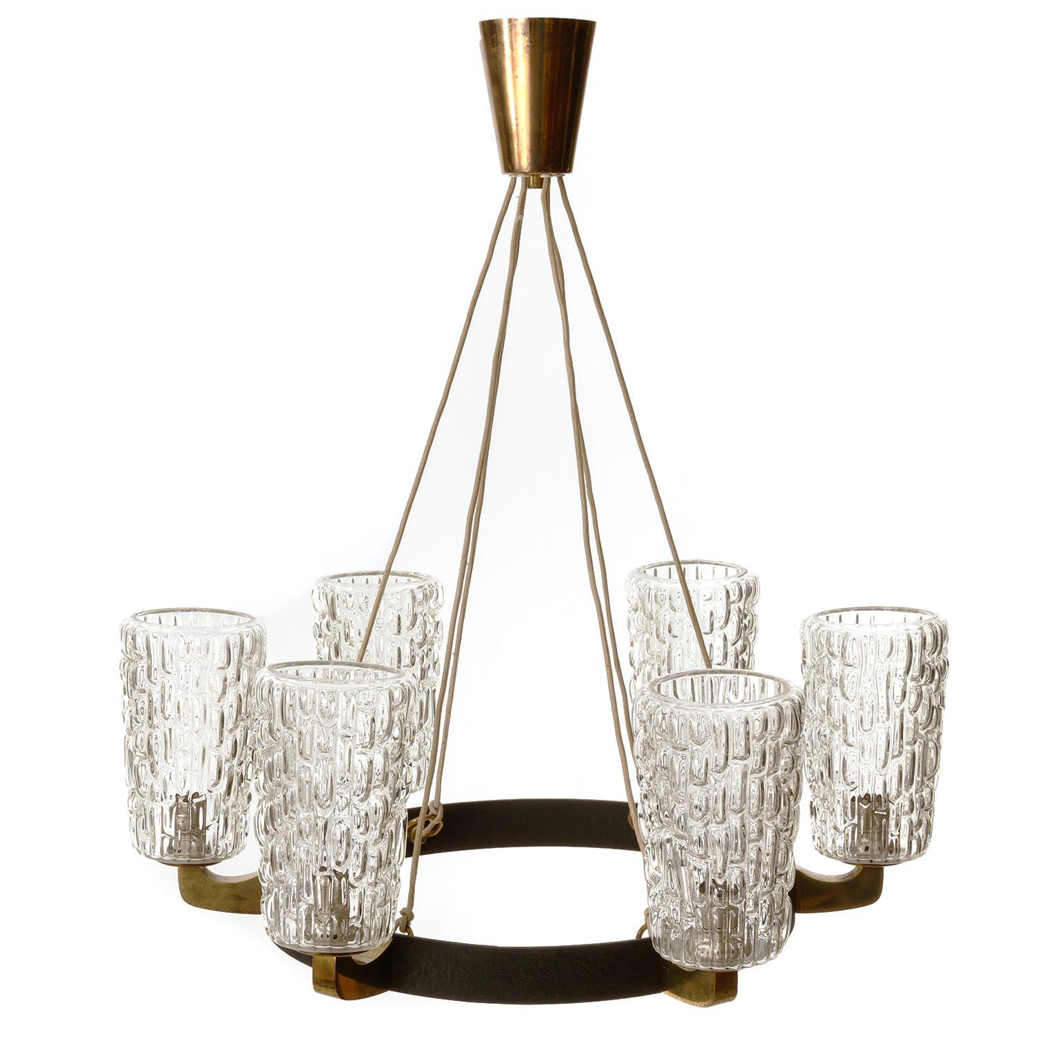 A large six-arm chandelier by Rupert Nikoll, Vienna, manufactured in midcentury, circa 1960 (late 1950s or early 1960s).
The fixture is made of a nice mixture of materials: large textured clear glass lamp shades, solid polished brass and black