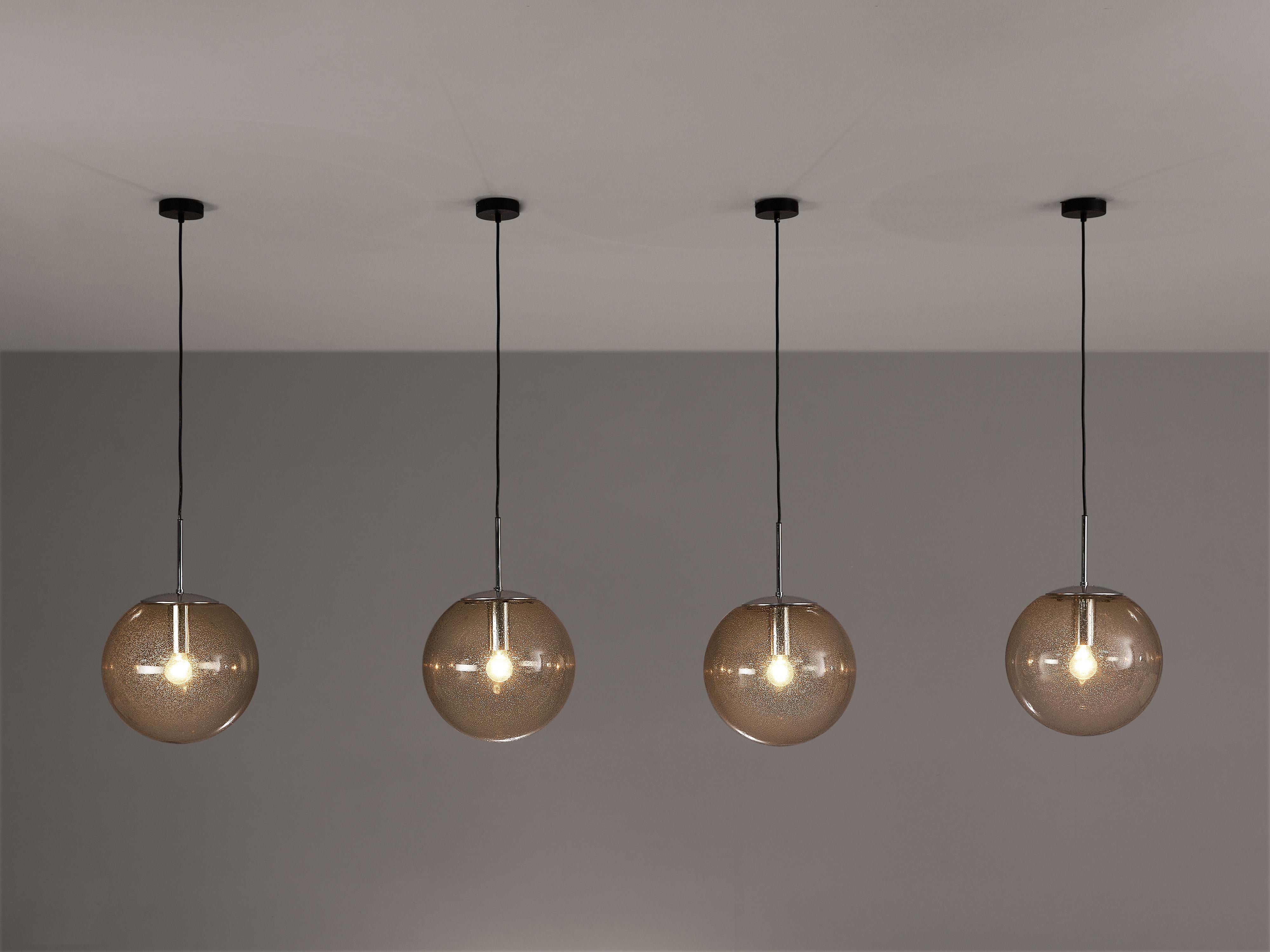 Pendants, smoked glass, chrome-plated metal, Europe, 1970s 

Set of blown glass pendants with multiple bubbles visible in the smoked glass orb. It not only gives the shade a playful appearance, it also creates a sparkling light partition. Another