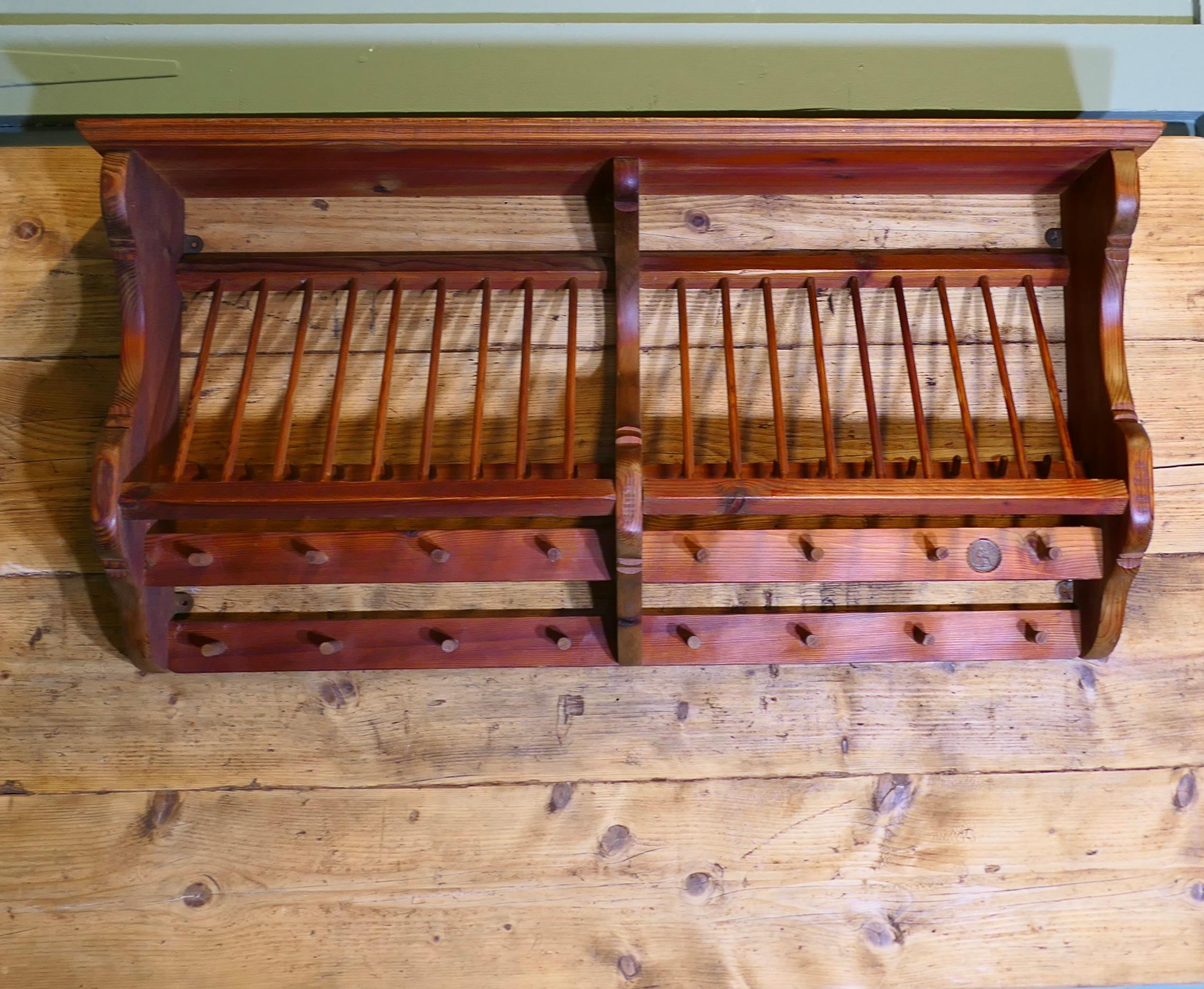 Large Penny Pine Wall Hanging Plate Draining Rack

This useful piece hangs on the wall and drains and stores plates and mugs until required, it has a 1937 penny set in the frame
It has a pine frame and wooden dowels with a scalloped shape allowing a