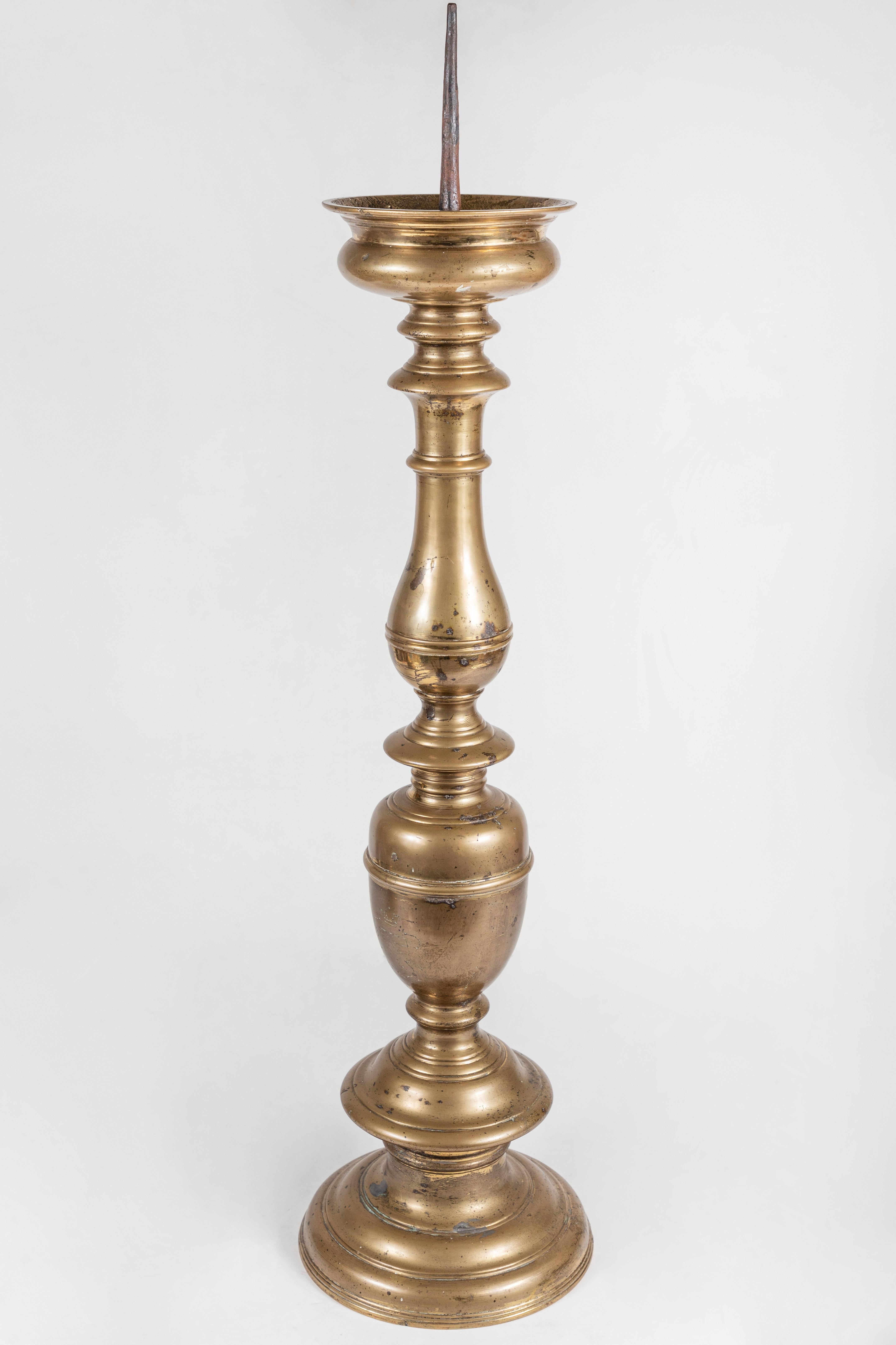 An absolutely grand pair of solid brass, turned, tiered candlesticks from Holland. One is engraved with a large, royal crest.
