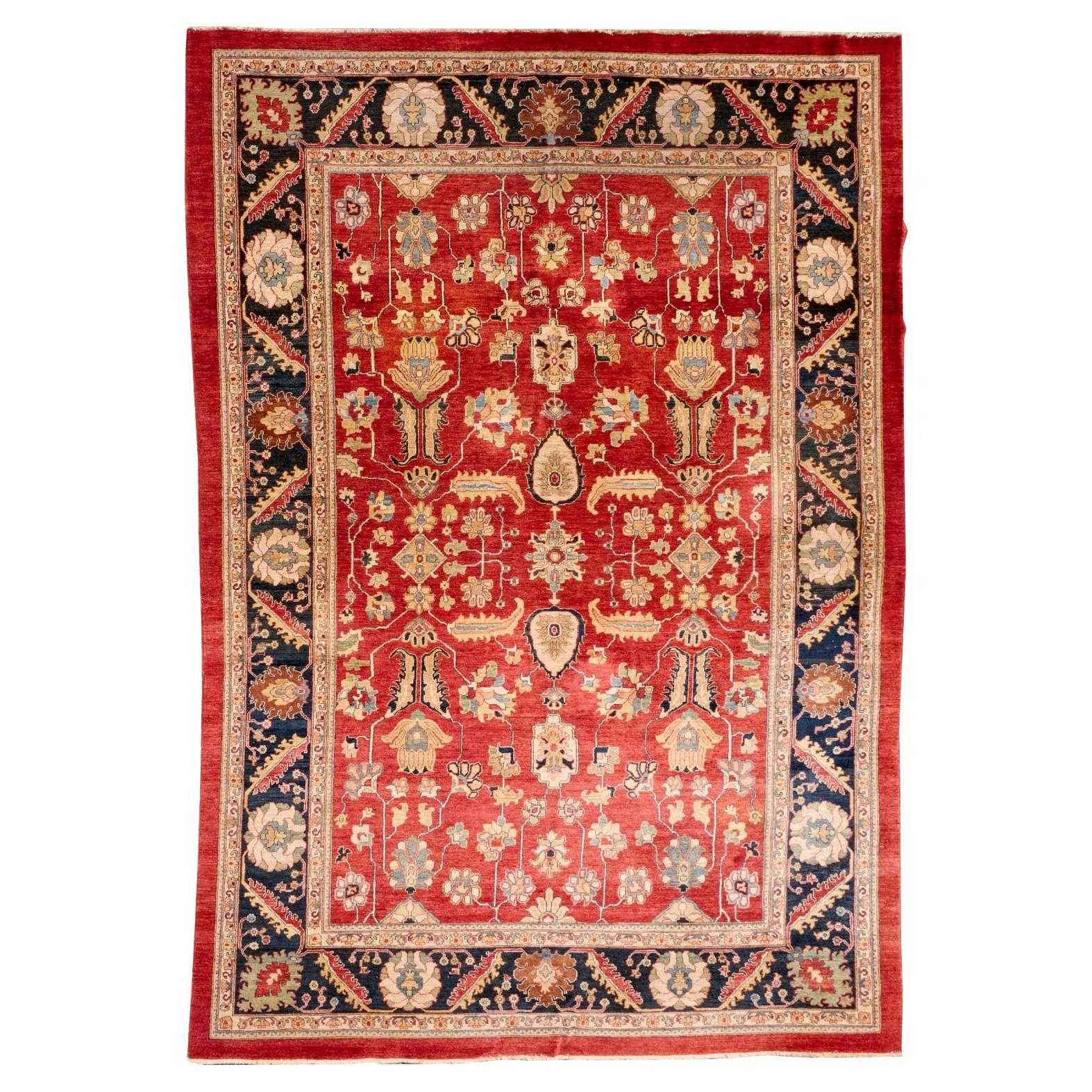 Gran alfombra persa de lana anudada a mano, campo rojo con borde azul marino, Mediados del S. XX en venta