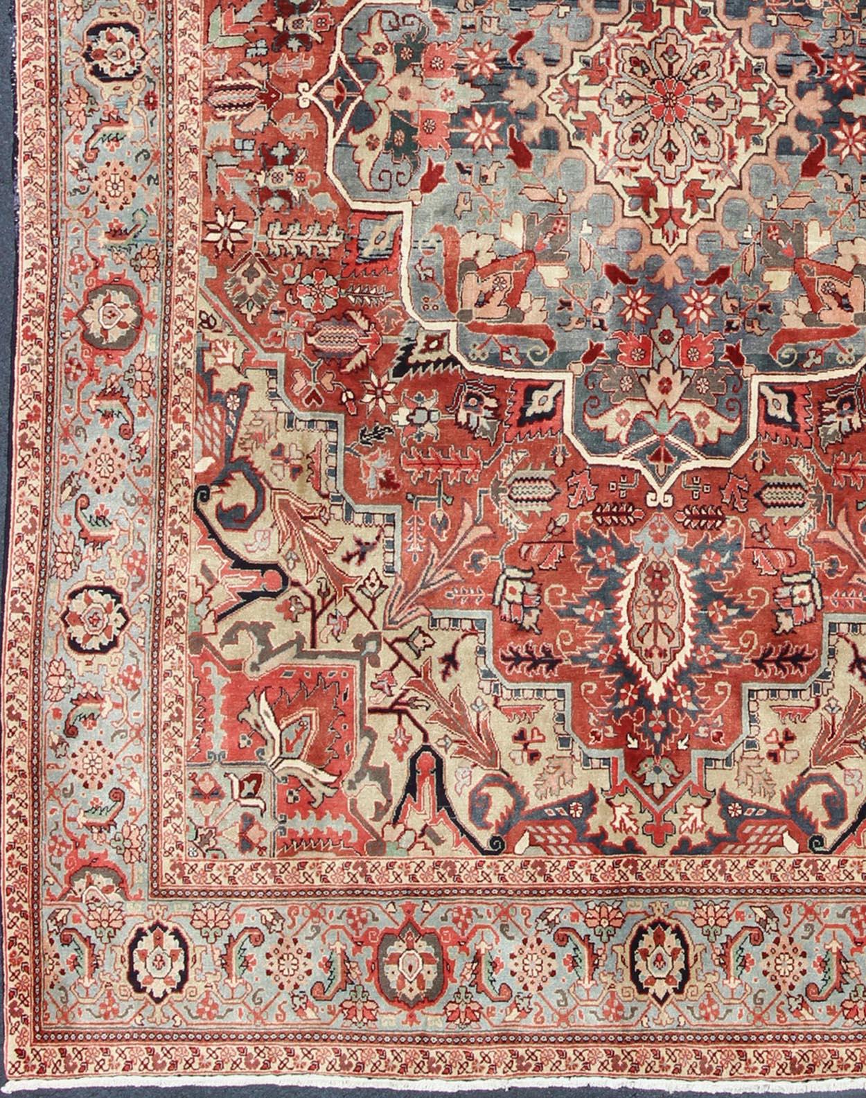 This exquisite vintage Persian Heriz carpet displays an impressively complex design and sophisticated palette. A refined central medallion is delicately drawn in ivory and is filled with a variety of palmettes and flowers. Beautiful feathered