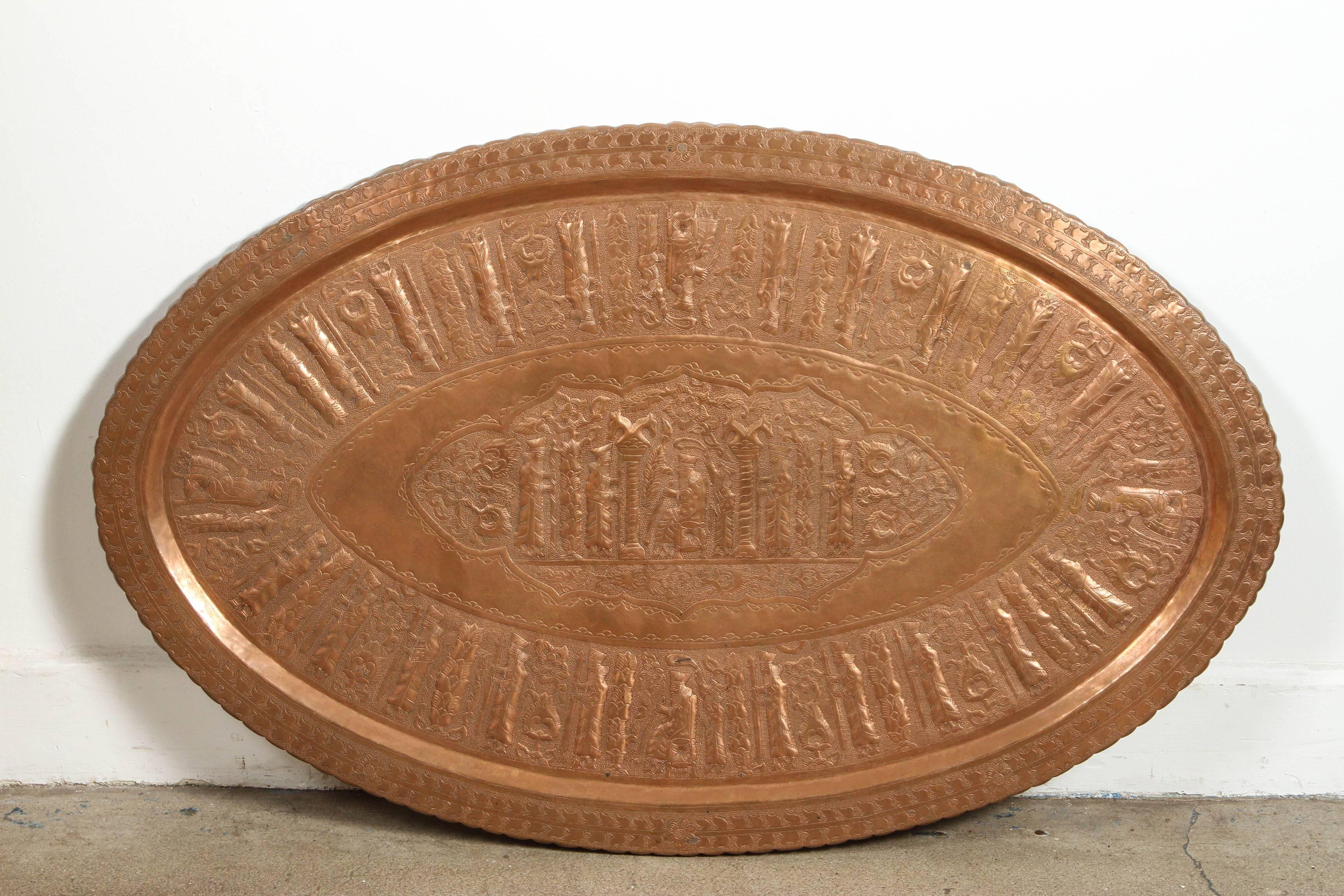 Great very large oval hand-crafted decorative copper tray.
Very fine Asian metal artwork, hammered and embossed with the Mythological story of the Persepolis Empire Kings, figures and geometric design.
Islamic Art, Moorish, Mameluke style Museum