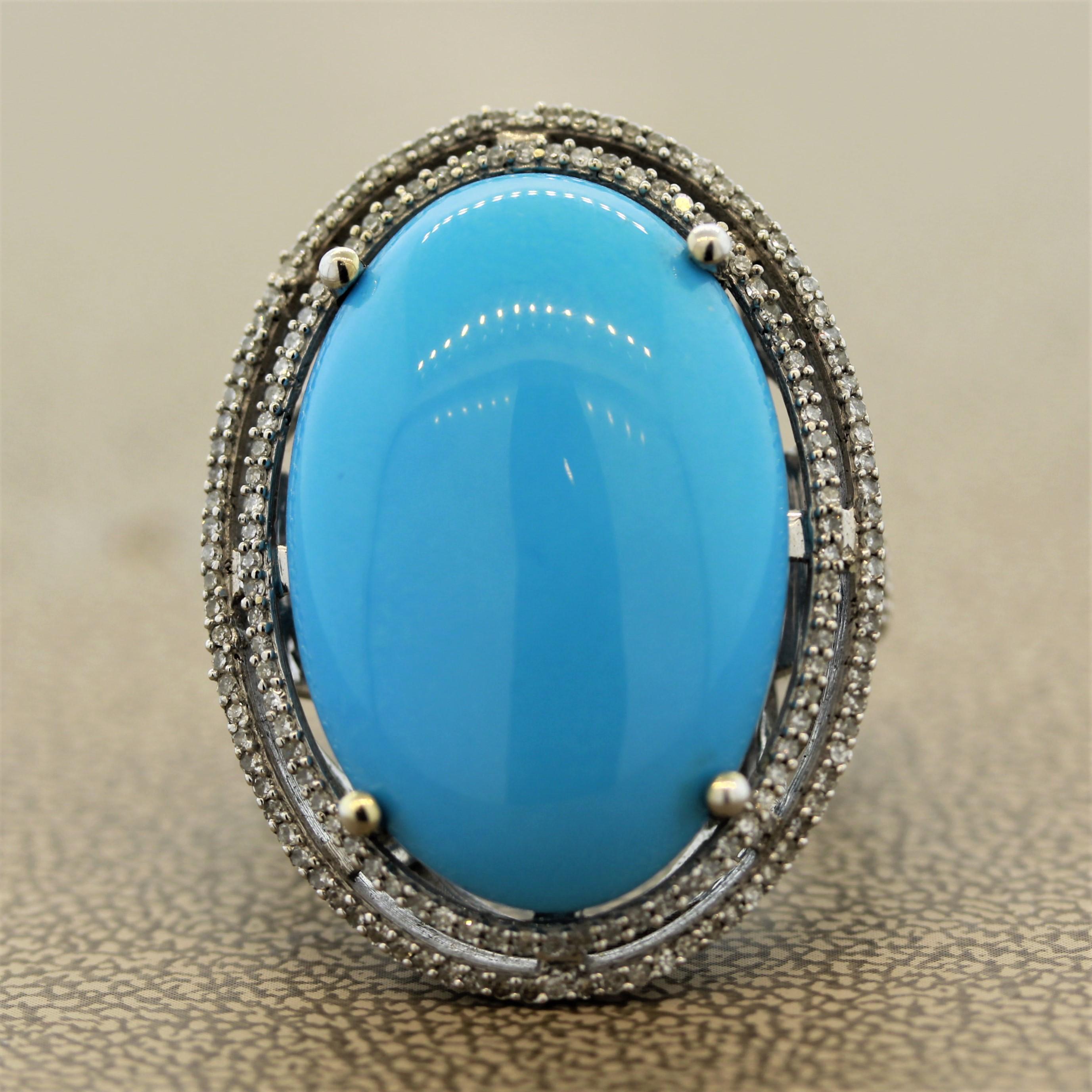 A large cocktail ring featuring a very fine sky-blue turquoise from Persia. It measures 26.8 x 18.5 millimeters and is accented by single cut diamonds making two halos around the turquoise and running down along the shoulders of the ring. Made in