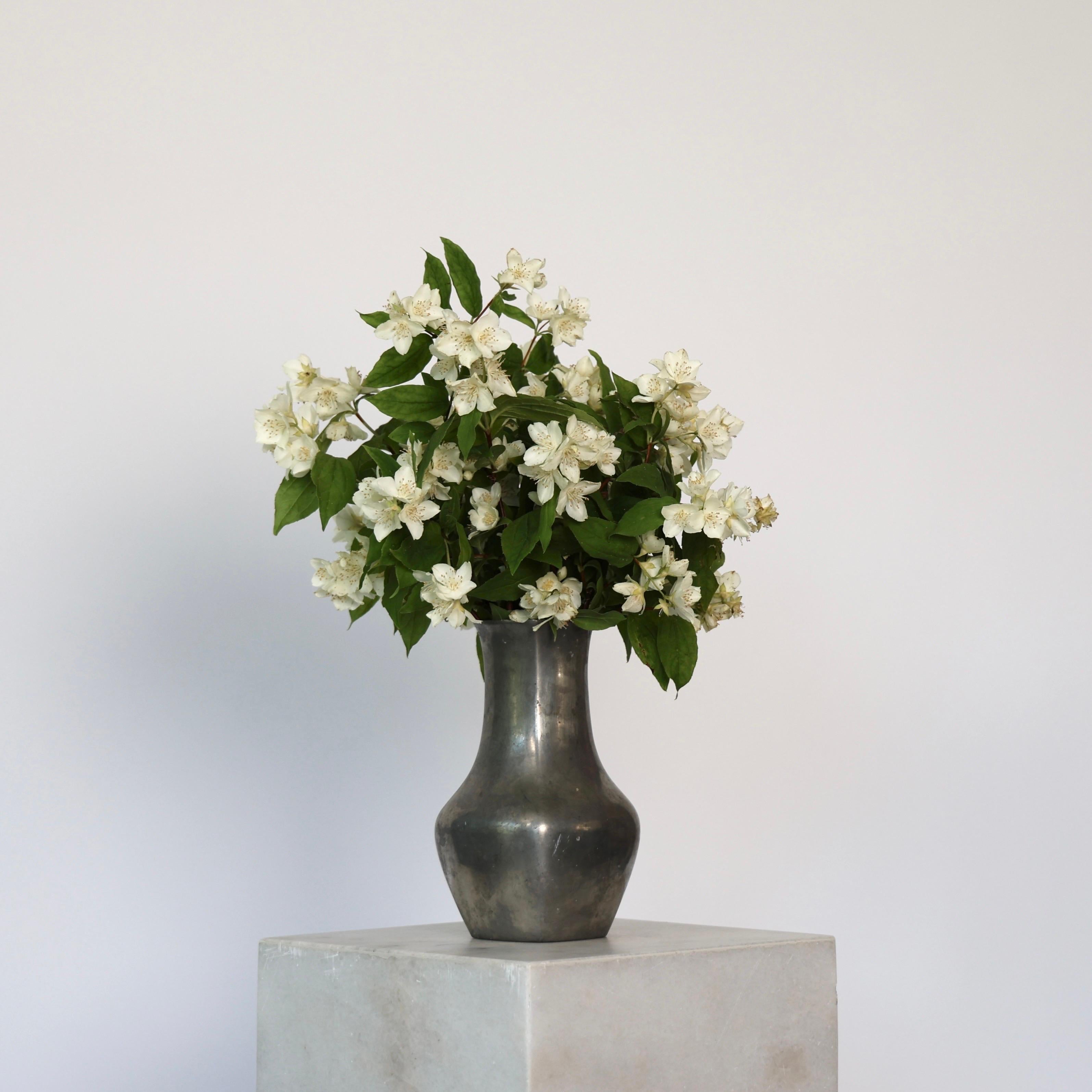 Large Pewter Vase made by Just Andersen in 1952. 

* Large square pewter vase 
* Manufacturer: Just Andersen
* Style: 2725
* Year: 1952
* Condition: Fair condition. Marks and scratches across, and limestone inside. 
* Dimensions (H x W x D): 19cm x